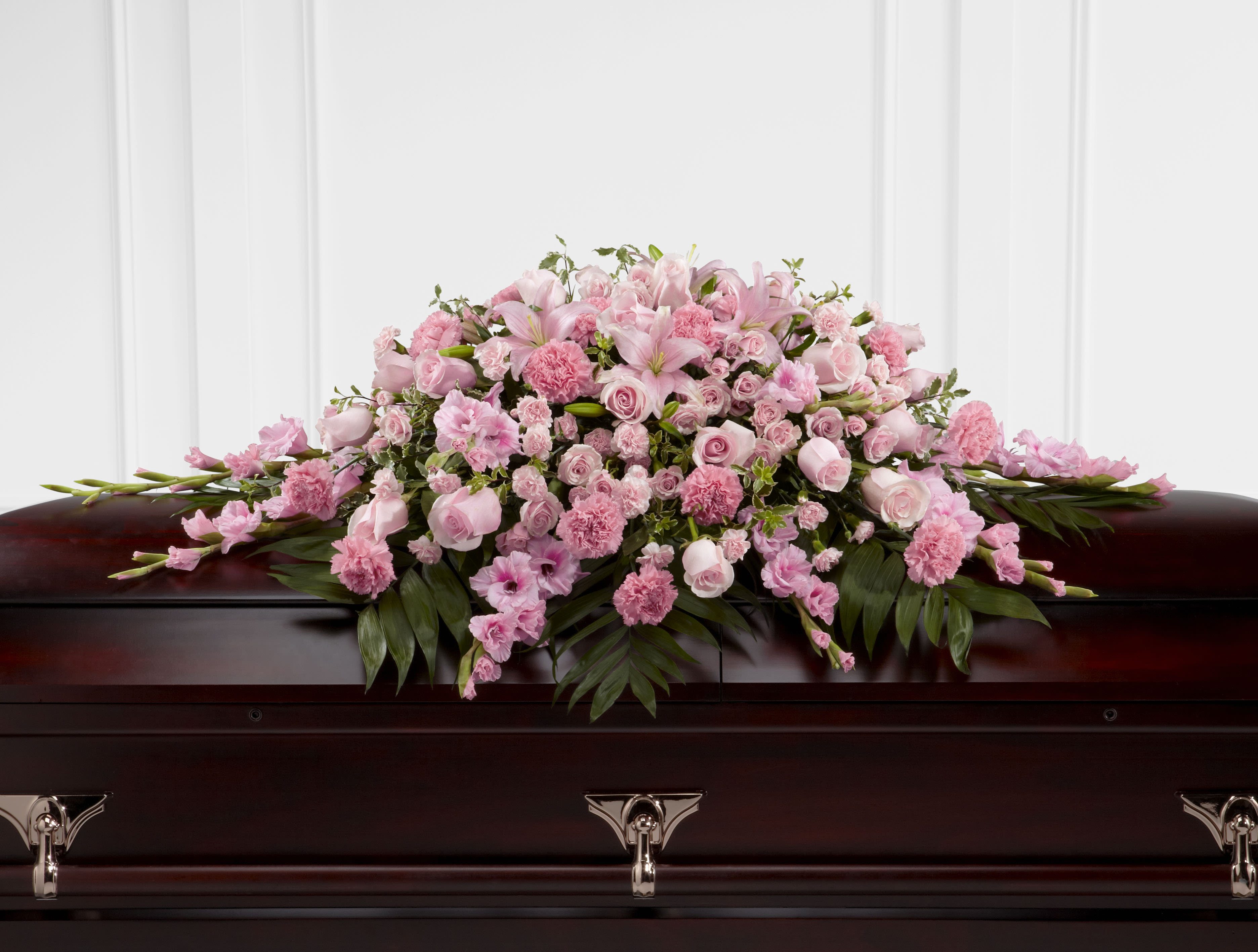 Sweetly Rest Sweetly Rest - The Sweetly Rest Casket Spray is a wonderful way to commemorate a life abundant in beauty and love. Blushing pink roses, spray roses, carnations, gladiolus, mini carnations and Asiatic lilies are elegantly arranged amongst an assortment of lush greens to create a sophisticated display meant to bedeck the top of their casket at the final memorial service
