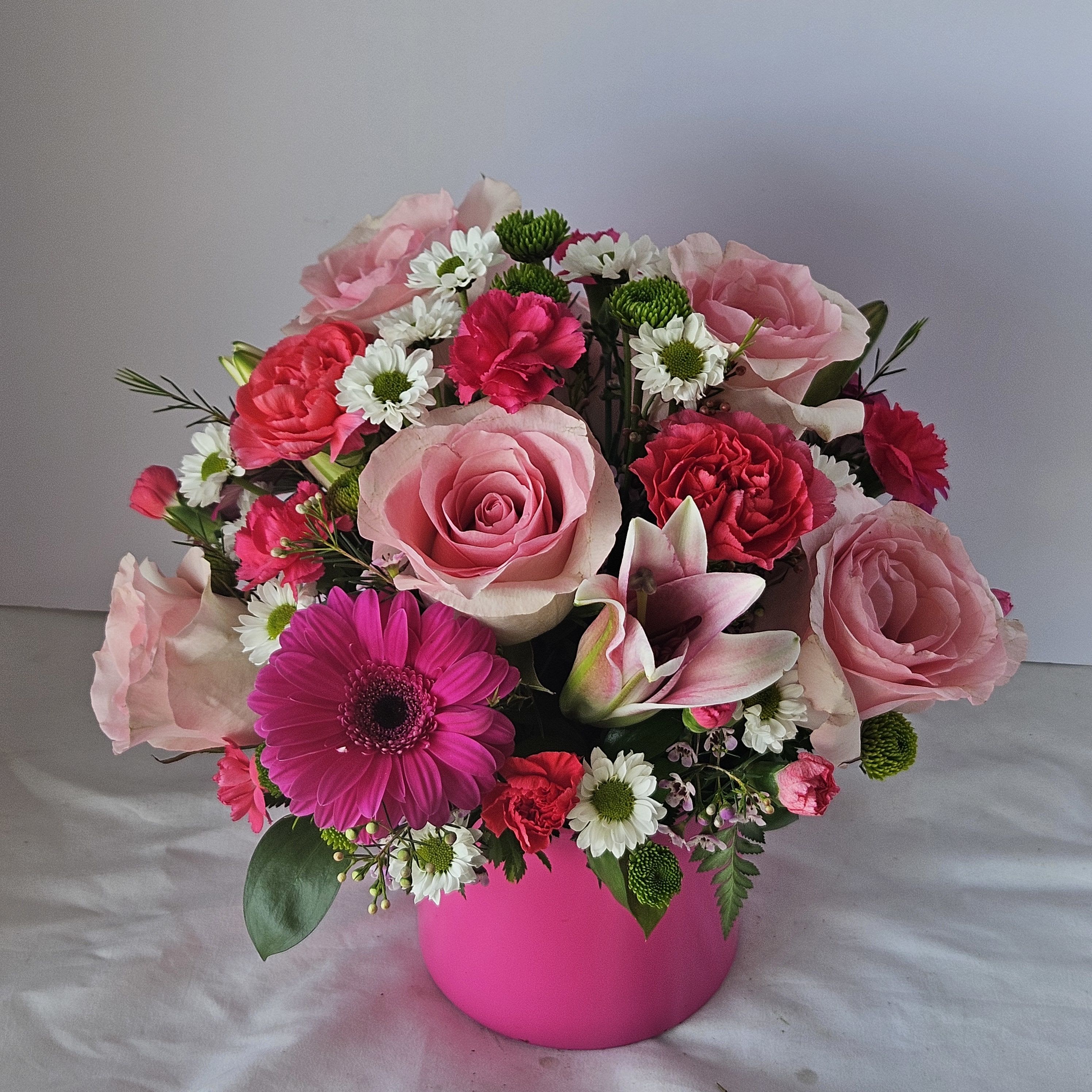 Pretty in PInk -  One look at this truly original arrangement of shades of pinks and whites, lilies, roses, carnations, and more will leave her smiling. We think it is a brilliant gift idea for birthdays, anniversaries or any day you want to put that special someone in the spotlight. Artistically created by FlowerBee floral artisans using the freshest flowers available so colors and varieties may vary.  Lilies may arrive in bud form and will open to full beauty over the next 2-3 days. To request a specific color scheme, please note in special instructions.