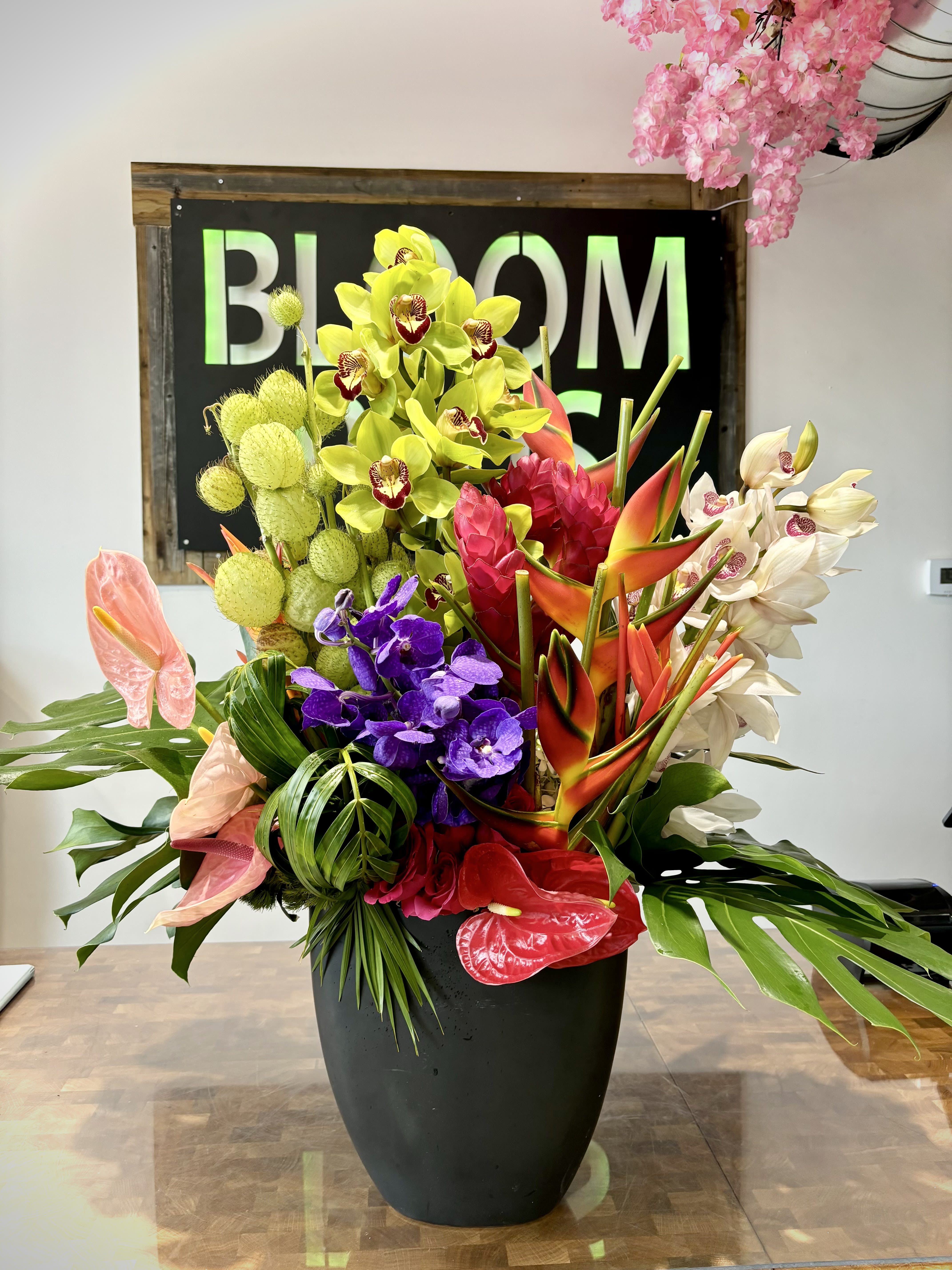 Paradise Luxe Paradise Luxe - A striking grand tropical arrangement bursting with vibrant colours, featuring lush exotic orchids, anthurium and bold foliage, artfully designed in a sleek black vase for a dramatic and sophisticated statement.