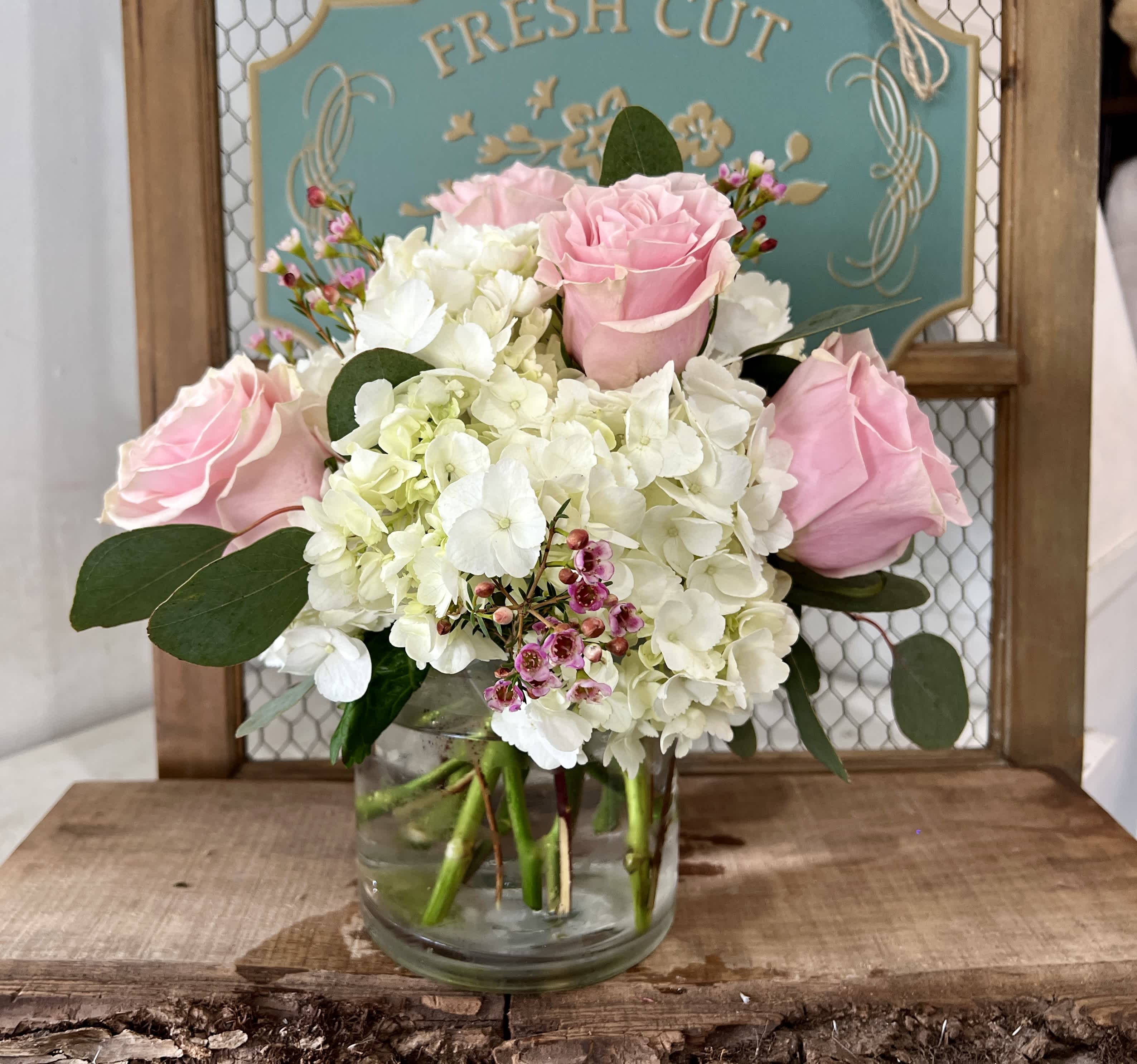 Bellissima - This enchanting floral arrangement features a delightful combination of hydrangeas, roses and wax flower, elegantly complimented by lush eucalyptus greenery. 