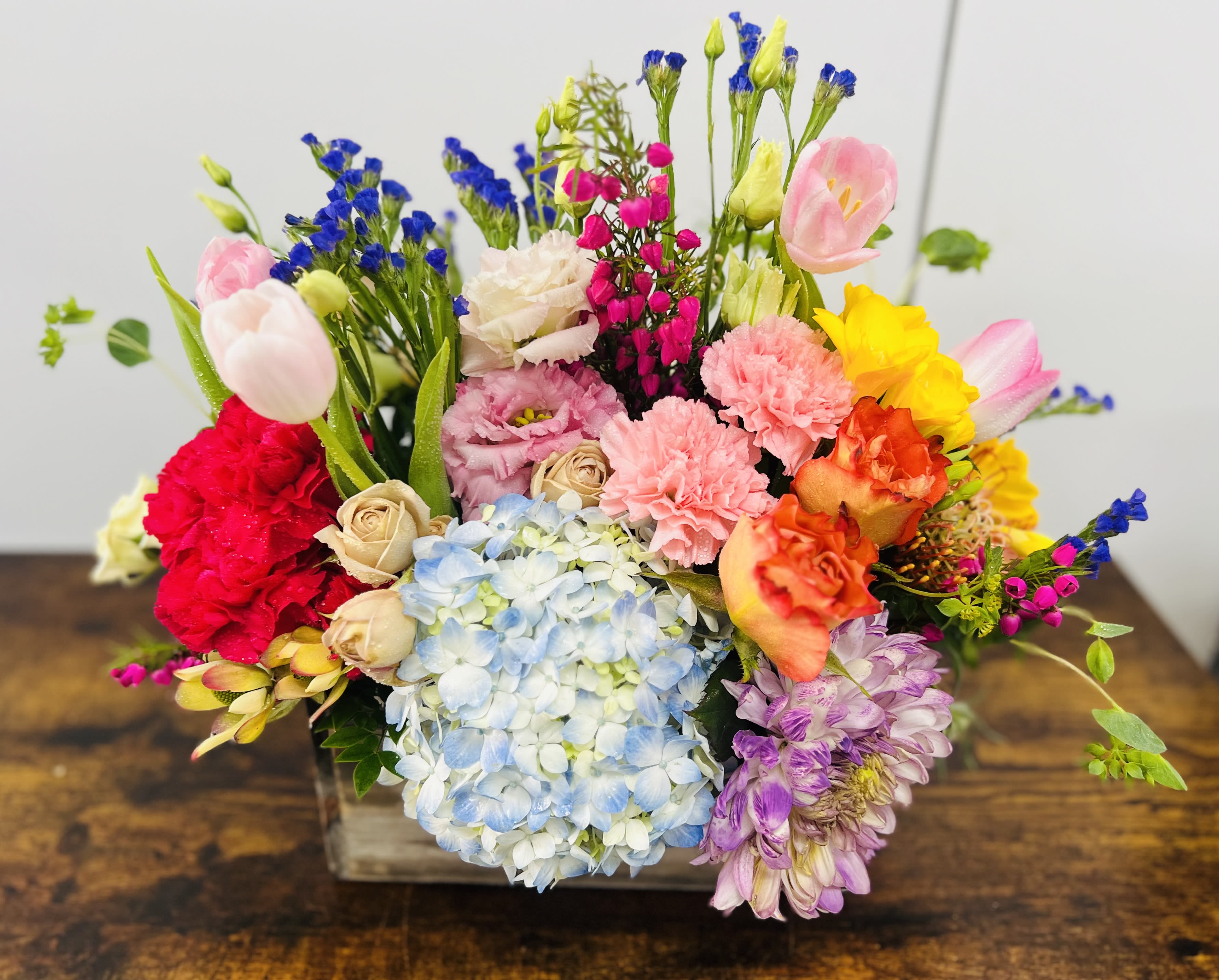 Mom's Garden Mom's Garden - This beautiful arrangement contains a mix of flowers such Blue hydrangea, Pink Tulips, hot pink carnations and mix of seasonal flowers. ***Flowers will be substituted with seasonal flowers****