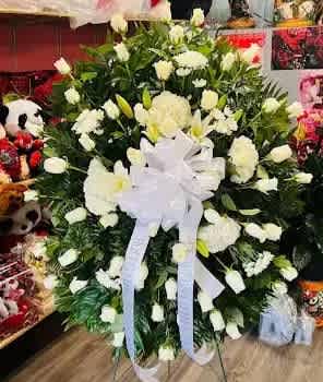 White standing Sympathy Spray - All white regular size sympathy standing spray  Includes Roses, carnations, lilies, with filler white mix flowers with Greenery