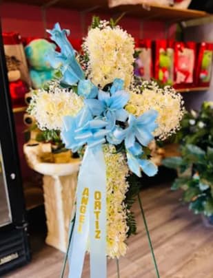 White &amp; baby blue Sympathy cross - Regular size Sympathy cross includes Roses, carnations. daisies, and lilies All white with baby blue flowers crossing Includes metal stand*