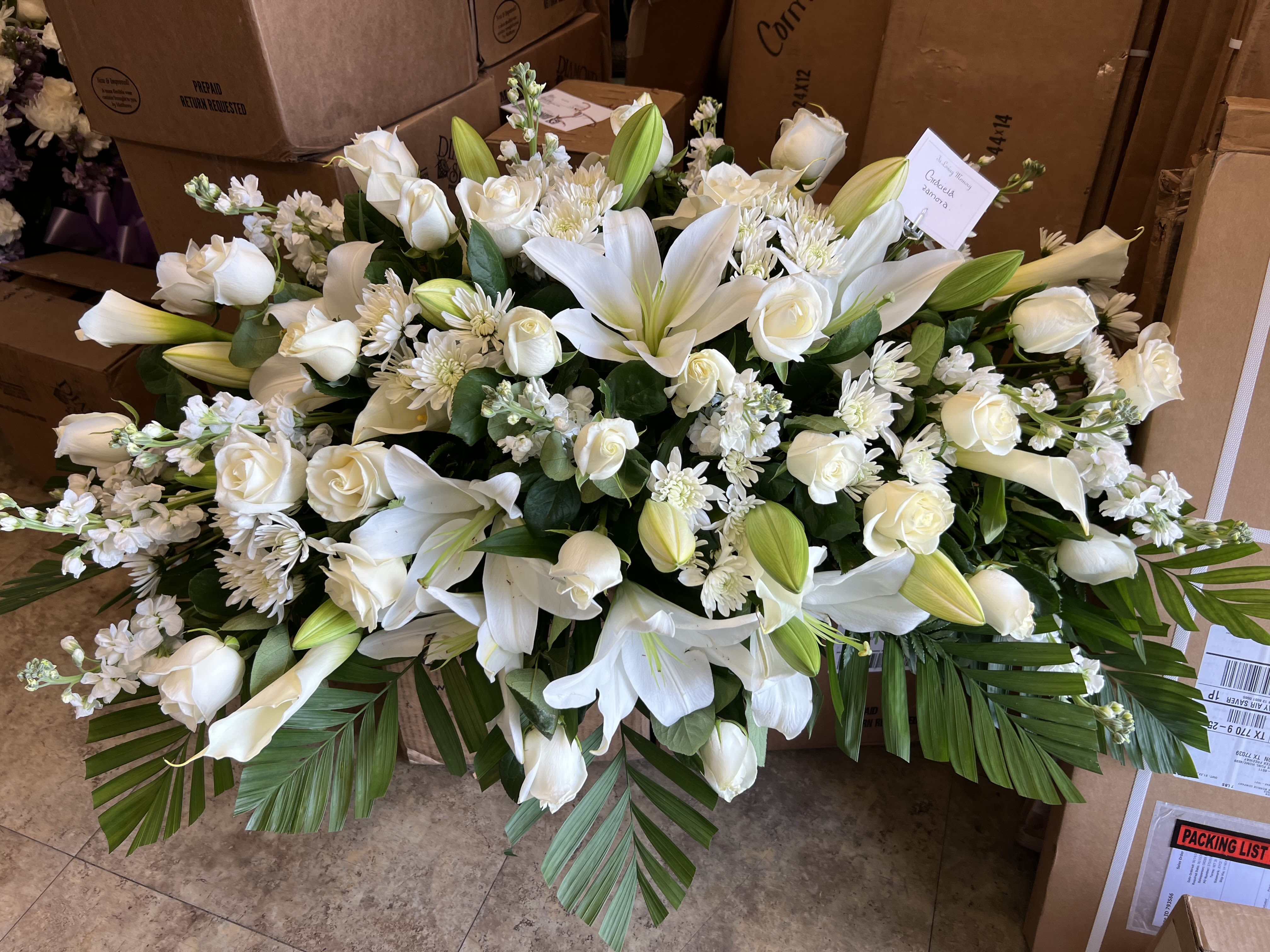 Peace by BloomNation™  - An all white tribute, this half casket spray is pure in color and heart. Featuring a variety of white flowers and greenery, this elegant half casket spray compliments the beauty of life. 