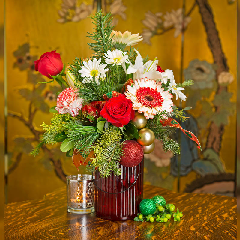 COUNTRY ROSE HOLIDAYS COUNTRY ROSE HOLIDAYS - RED ROSES, CANDY CANE CARNATIONS AND GERBERAS, AND DAISIES WITH A LOVELY MIX OF CHRISTMAS GREENS. THE BEST PART OF THIS ARRANGEMENT IS THE VARIETY OF ORNAMENTS DECORATING THE DESIGN.