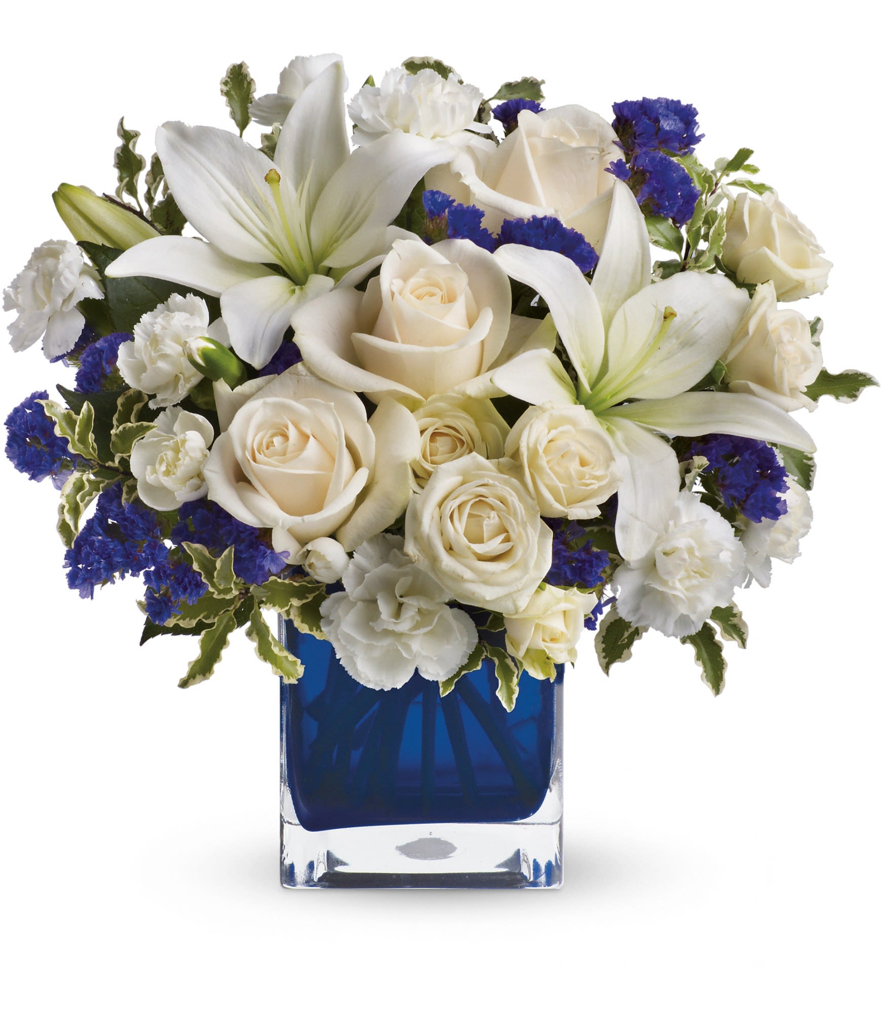 Teleflora's Sapphire Skies Bouquet Teleflora's Sapphire Skies Bouquet - Send someone a bit of heaven with this beautiful bouquet. Luxurious crème roses and pure white lilies paint a peaceful picture inside a sapphire blue cube.