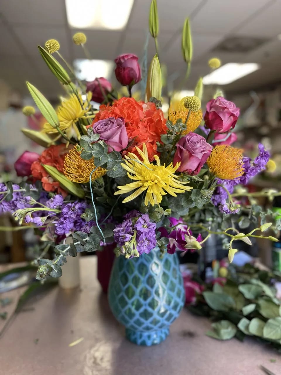 It's a Vibe It's a Vibe - This arrangement it large and in charge! Bringing it's own vibe to any occasion! This gorgeous bouquet has a wide range of flowers. Eucalyptus, pin cushion protea, lilies, spider mums, hydrangea, stock, roses, and fun yellow Billy Balls... What more could you want?