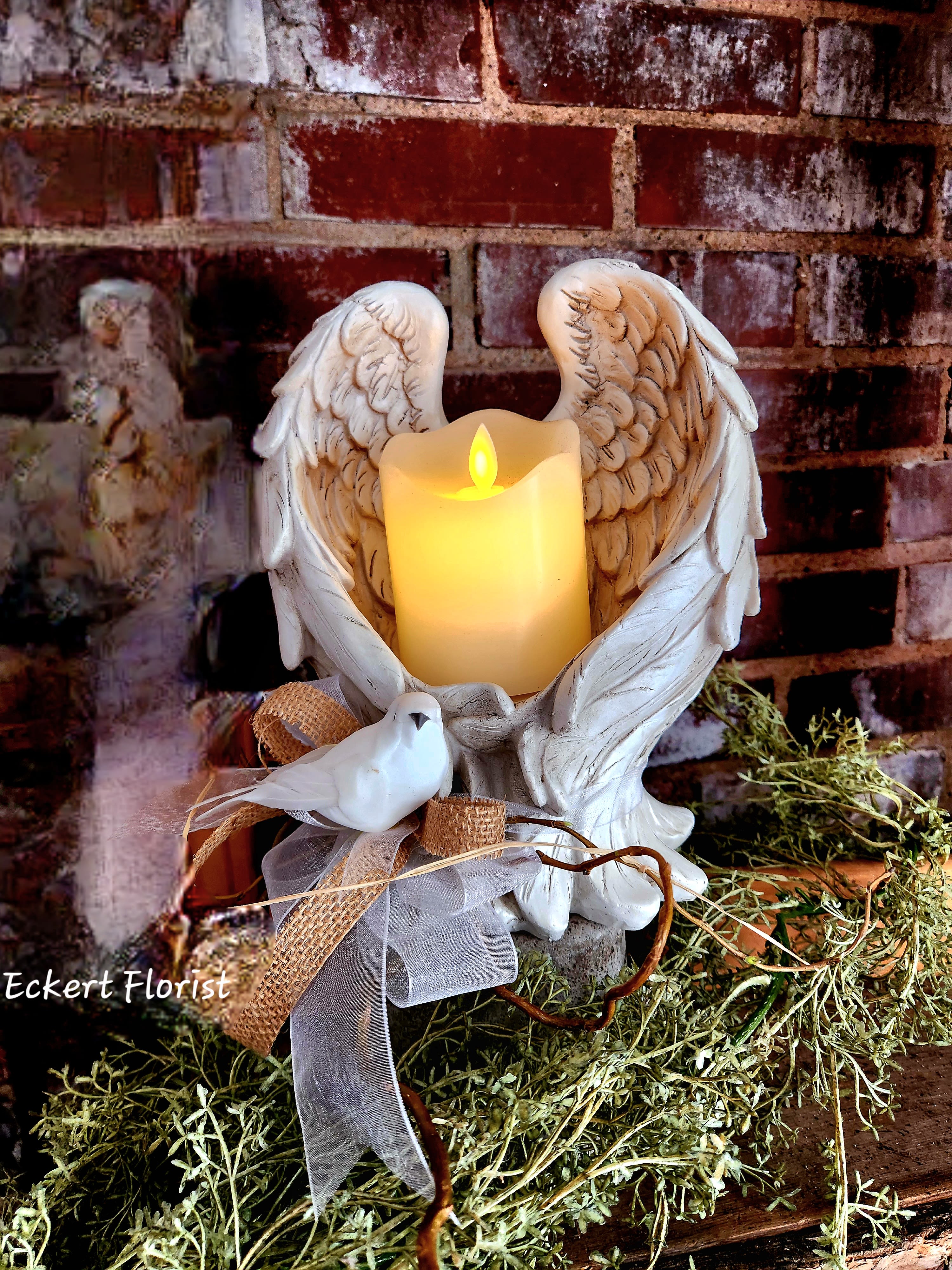 Eckert Florist's Angel Wings Candle Holder *Our Local Delivery Only Eckert Florist's Angel Wings Candle Holder *Our Local Delivery Only - This resin angel wings candle holder (9.75" H x 8" wingspan) would make a lovely memorial keepsake. Arrives with a battery operated candle, twig , bow, and dove bird. *Our local delivery only