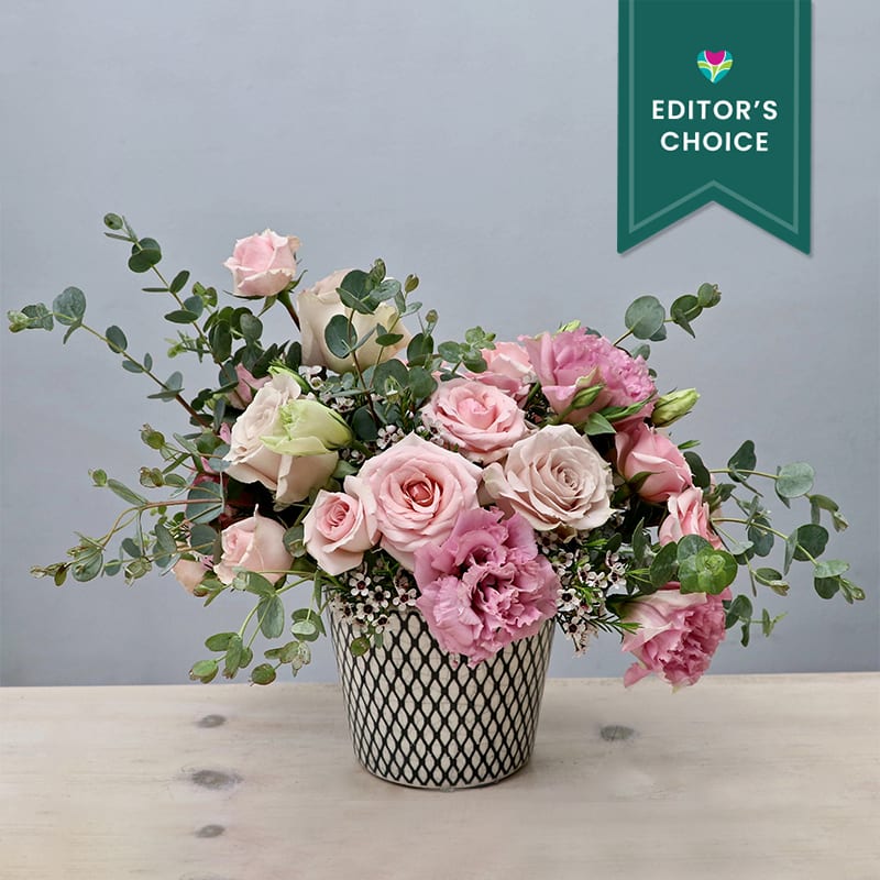 Pink Sunshine - West Hollywood Flowers (Editor's Choice) Pink Sunshine - West Hollywood Flowers (Editor's Choice) - This arrangement really is a spark of sunshine. Sure to make any recipients smile as soon as they receive it. Full of pink roses, lisanthus, and eucalyptus. Standard size measures approximately 10x10'' make sure to upgrade for a larger size and a bigger impression.