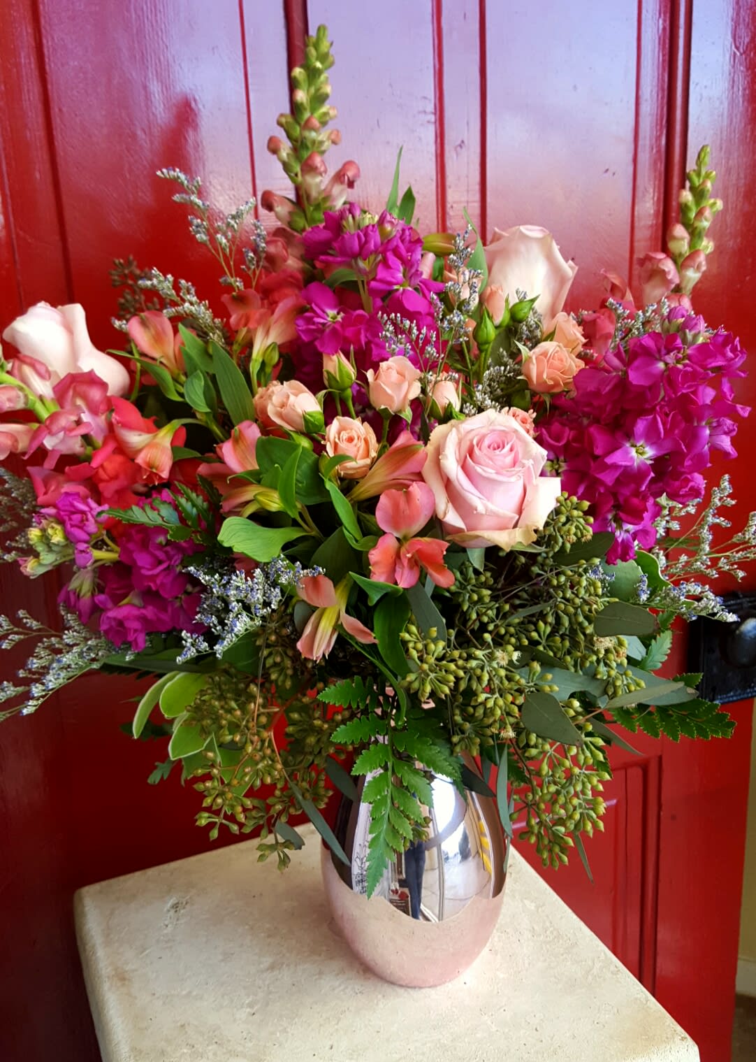KISS ME... KISS ME... - BEAUTIFUL HUES OF REDS AND PINKS COMPLETE IN A PINK MIRRORED VASE THAT COMPLEMENTS THIS STUNNING ARRANGEMENT. MAKE SURE TO SEND THIS TO THEIR WORK PLACE SO THEY CAN SHOW IT OFF AND YOU'LL BE SURE TO GET AN "A" FOR EFFORT!!!
