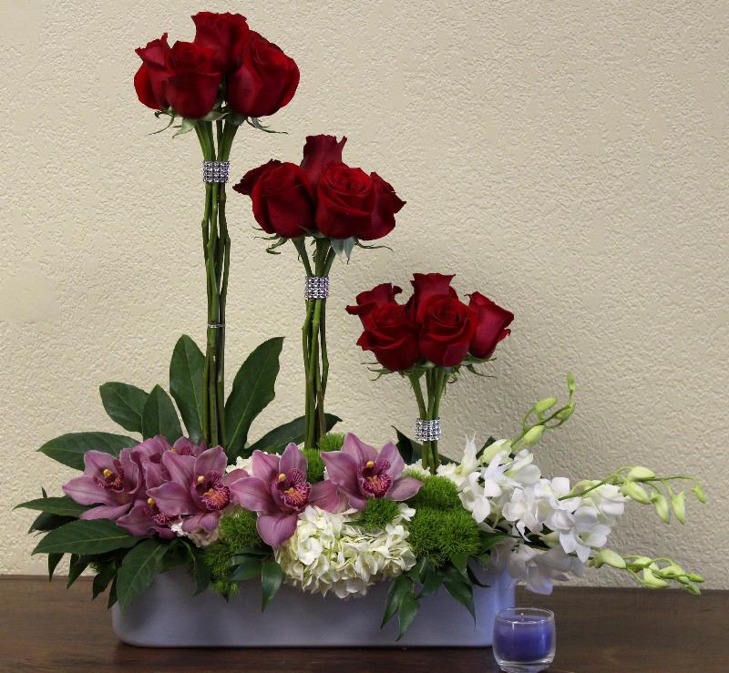 Marilyn Marilyn - This bold arrangement is a sure crowd pleaser. The combination of roses, orchids, and hydrangea will enhance the beauty in any room!