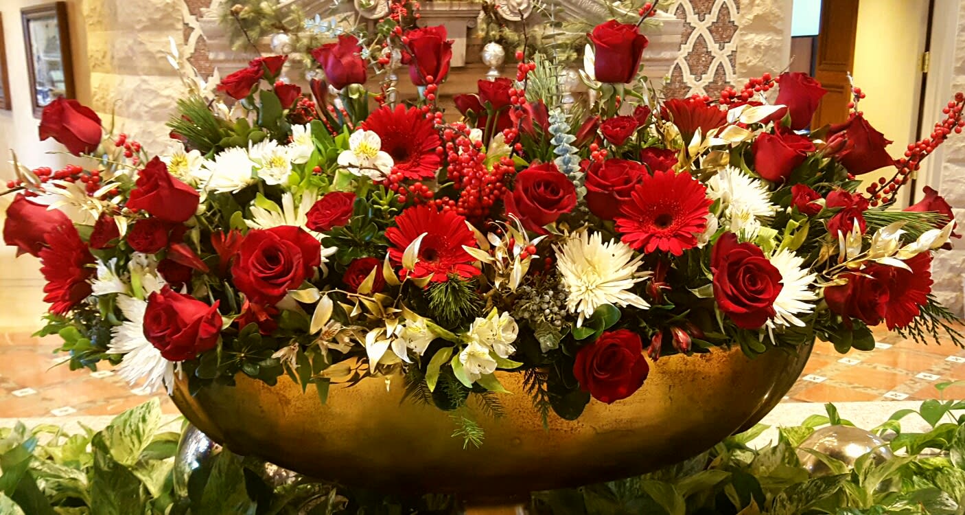 Ruby and Bright - A lovely design of ruby red and hints of snow whites. Breathtaking red roses, gerbera daisies, mini carnations and red Ilex berries all designed together with stark white china mums, alstromeria, and a hint of gold ruskus.