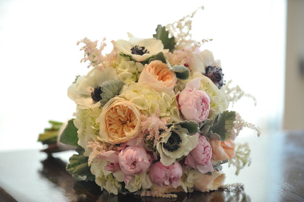 SHERBET WISHES HAND-TIED SHERBET WISHES HAND-TIED - A BED OF WHITE HYDRANGEA TOPPED OFF WITH PEACH GARDEN ROSES, PALE PINK PEONIES, GORGEOUS ANEMONE, AND SOFT HINTS OF LAMBS EAR GREENS. HAND WRAPPED IN CREAM COLORED SATIN.