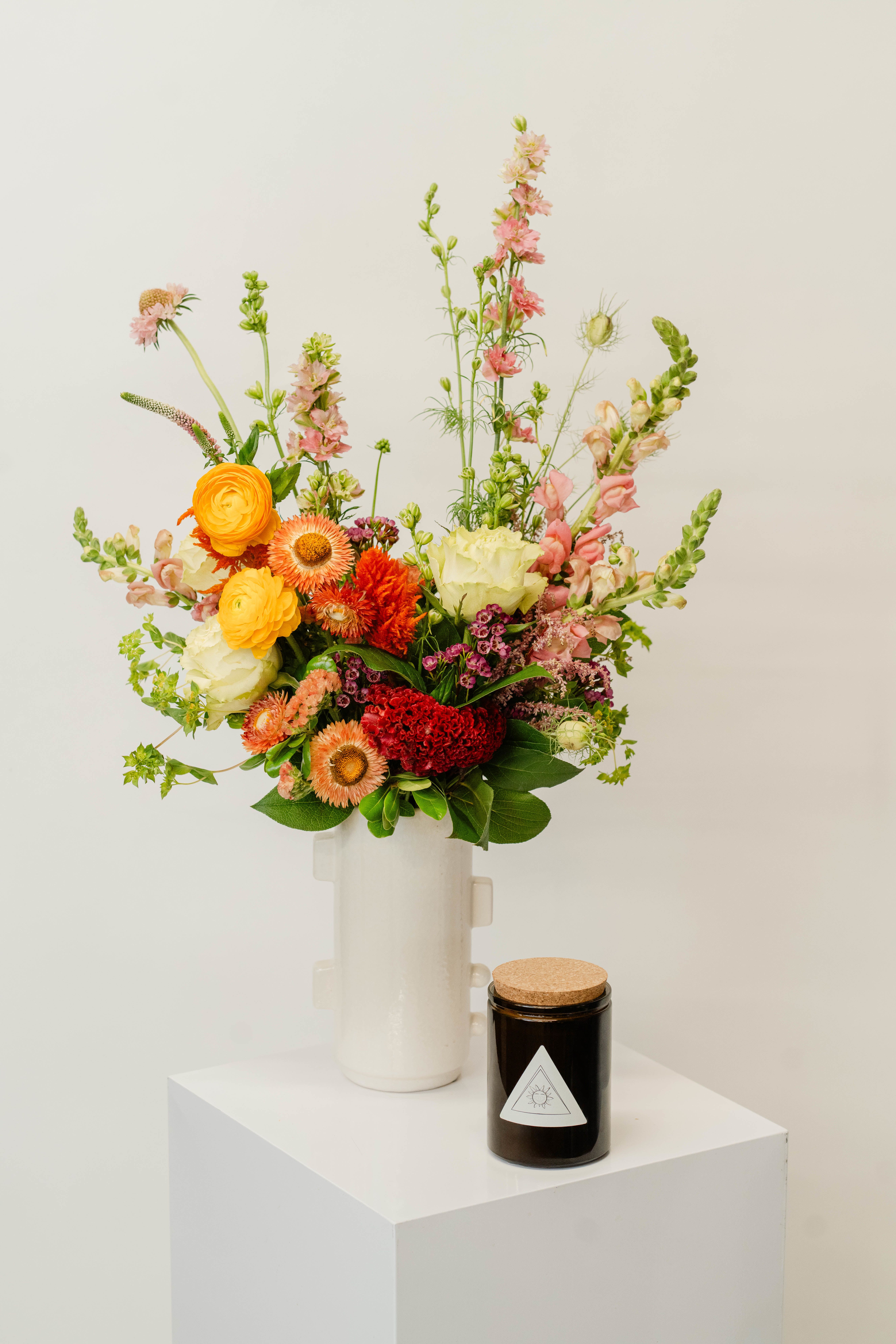 Large Vase Design + Candle Bundle - Our large curated case design bundle features a stunning fresh floral arrangement paired with a handcrafted candle, designed to make a bold and elegant statement. Perfect for transforming your space or gifting with impact, this bundle brings together vibrant blooms and warm ambiance for a truly memorable experience.  