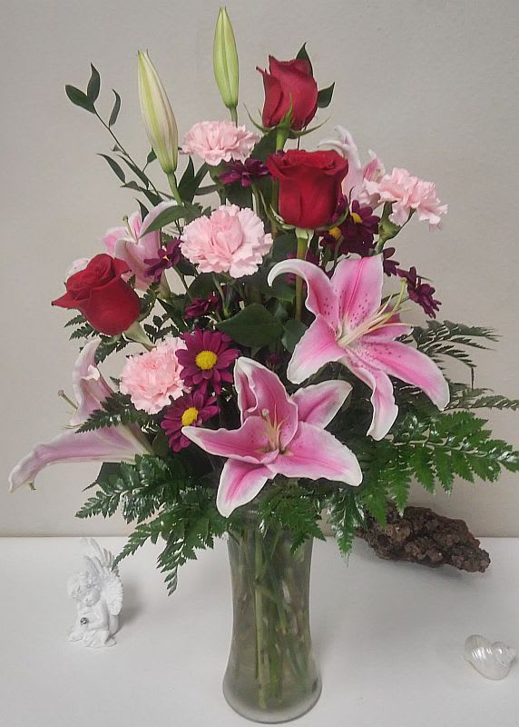 From the Garden From the Garden - Does someone you know need a pick-me-up? Lift their spirits – and make the day special – by sending this charming display of blushing blossoms in shades of pink, red and purple. It’s the perfect all-occasion, fresh-from-the-garden bouquet.
