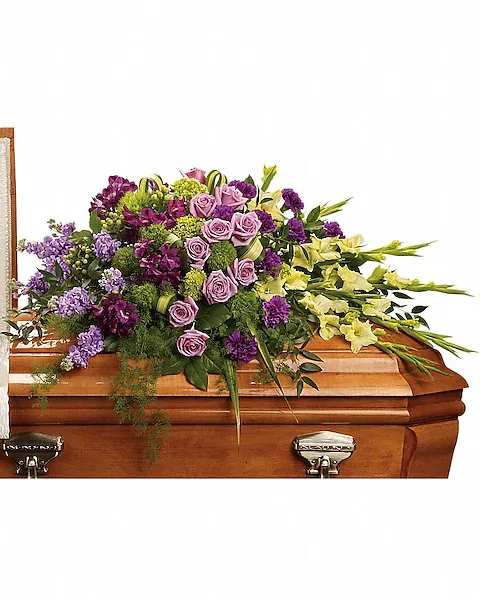 Reflections of Gratitude Casket Spray - Devotion is beautifully expressed with lavender roses, purple alstroemeria and other favorites artistically arranged and placed on top of the casket. The lush arrangement includes green miniature hydrangea, lavender roses, purple alstroemeria, green gladioli, green trick dianthus, purple carnations, lavender stock and green hypericum, accented with assorted greenery.