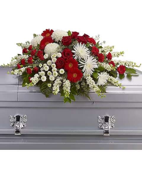 Strength and Wisdom Casket Spray - This beautiful red and white spray will deliver strength and the wisdom to know that there will be brighter days ahead. Dazzling red roses and gerberas, brilliant white chrysanthemums and larkspur are arranged with gentle greens to create a strong yet soothing arrangement.  