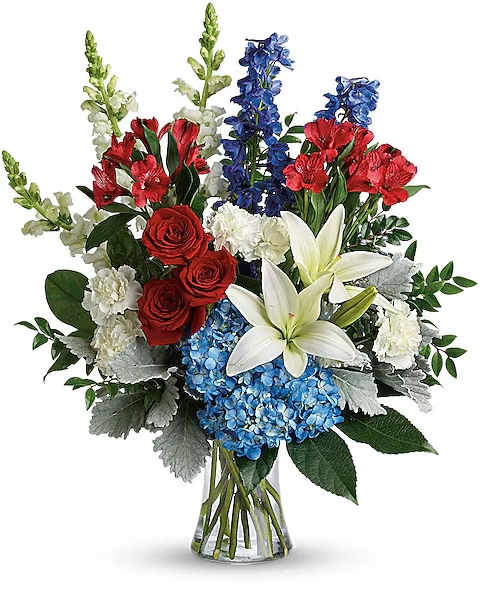 Colorful Tribute Bouquet - Perfectly patriotic with its red, white and blue blooms, this bold bouquet of hydrangea, lilies and roses is a versatile tribute on any occasion. This bouquet features blue hydrangea, red roses, white asiatic lilies, red alstroemeria, white carnations, blue delphinium, white snapdragons, huckleberry, dusty miller, aralia leaf and lemon leaf. Delivered in a gathering vase.  