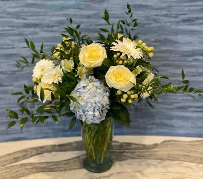 Blue-tiful! - Our blue-tiful arrangement is the most amazing mix of premium flowers. This arrangement includes a variety of premium flowers and colors. Hydrangeas, gerber daisies, roses and hypericum with a mix of greens will amaze your recipient.