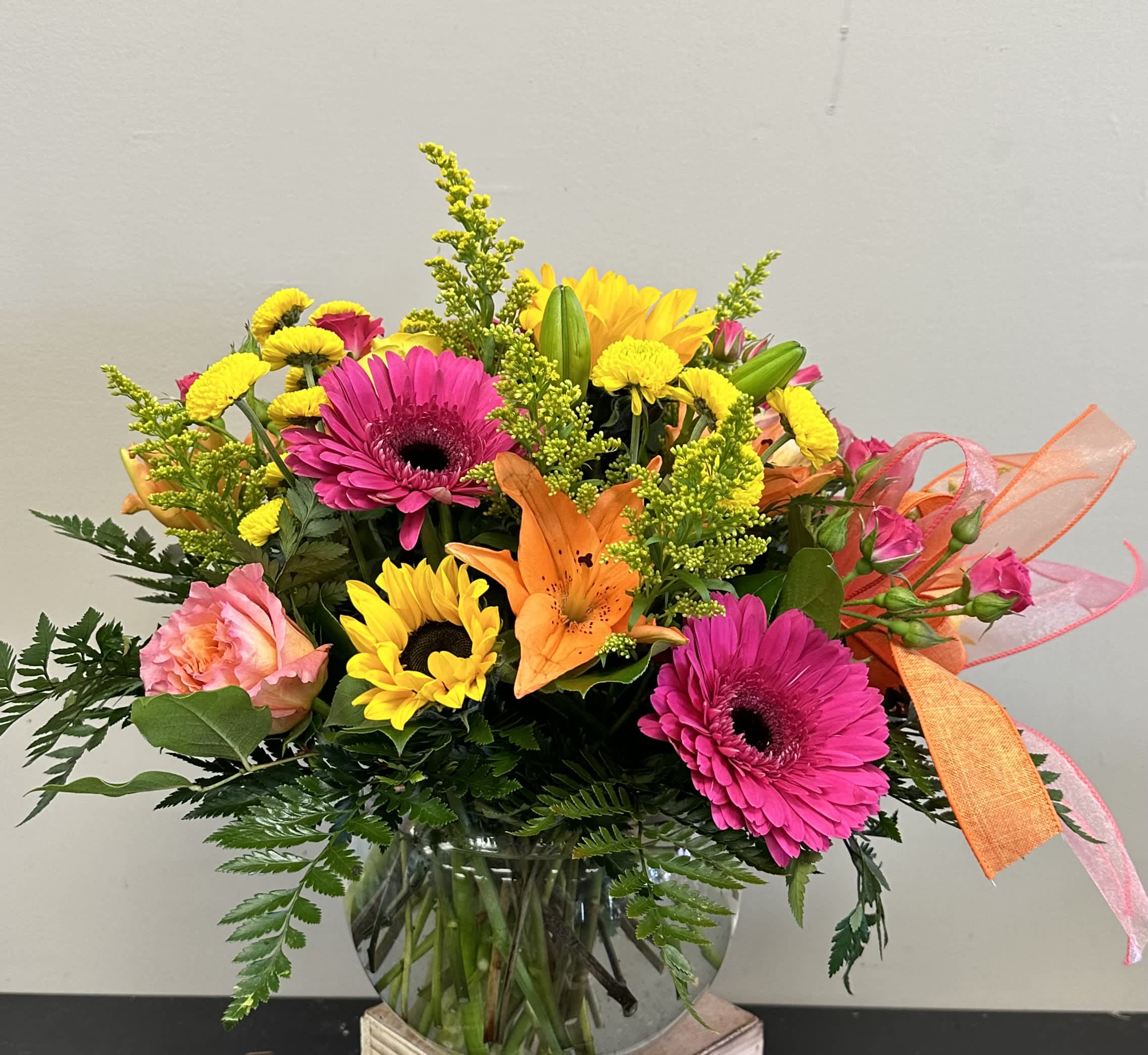 Springtime Sun - Bright spring florals consisting of sunflowers, orange asiatic lilies, pink gerbera daisies, coral roses and yellow button poms