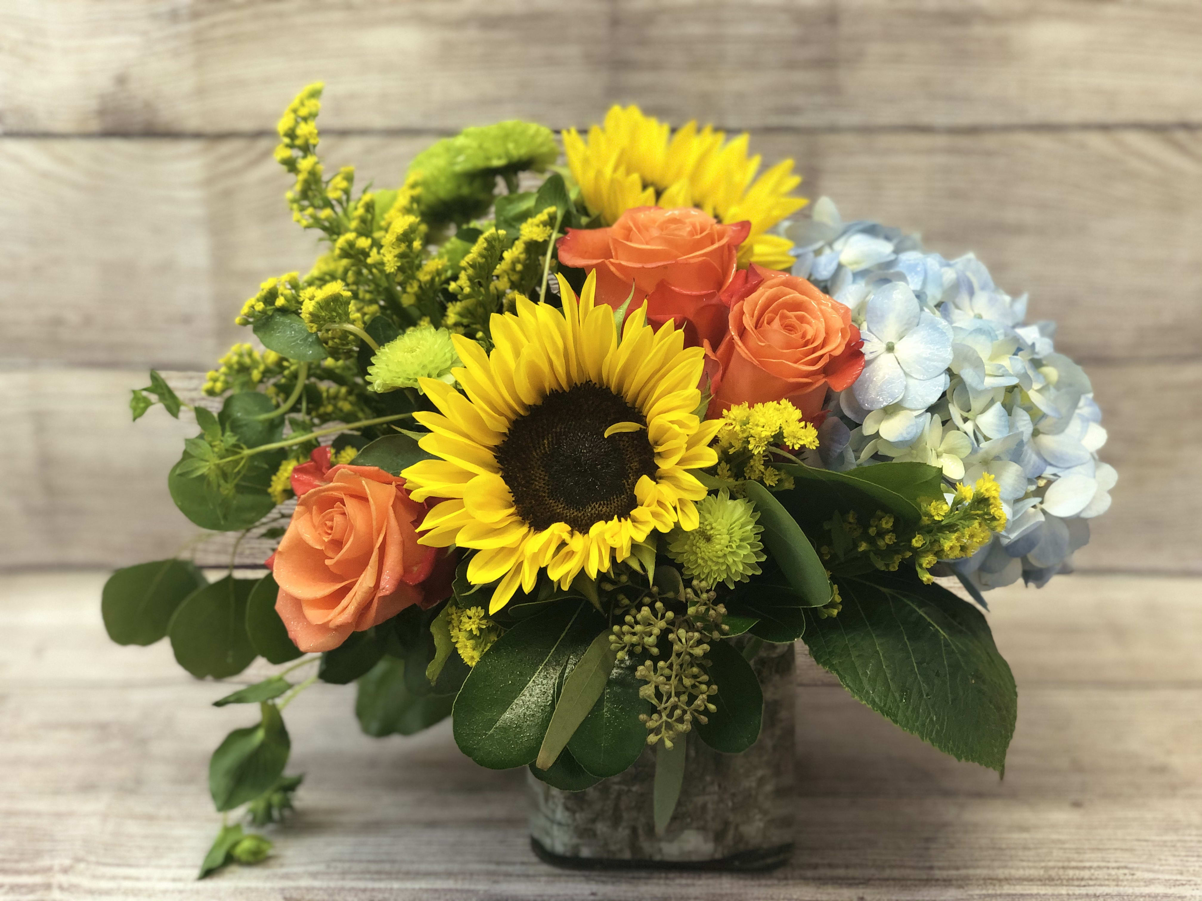 Breath of Fresh Air by BloomNation™ - This is the perfect gift for someone who can use some R &amp; R. The arrangement contains roses, hydrangea, sunflowers  and other seasonal blooms. 