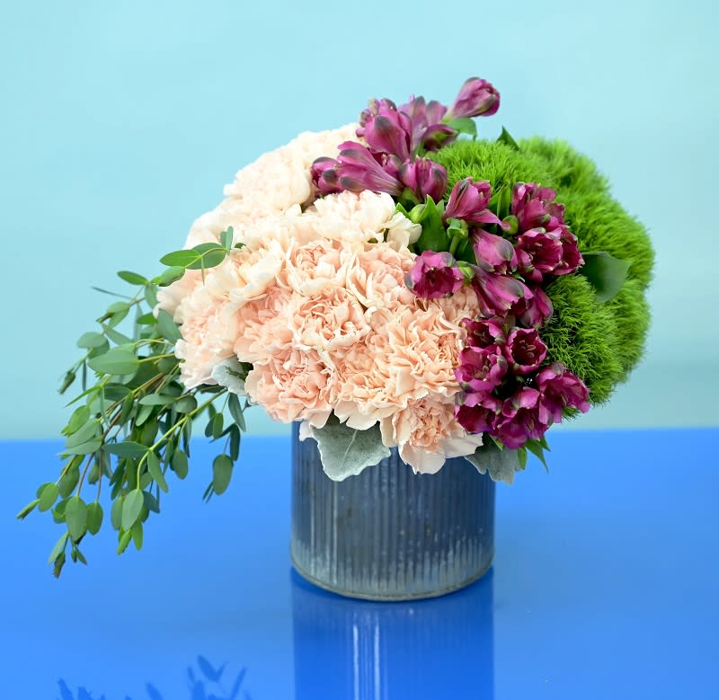 Raleigh Blooms Raleigh Blooms - Introducing "Raleigh Blooms," a delightful floral arrangement that captures the essence of natural beauty and rustic charm. This arrangement showcases lovely light pink or peach carnations, complemented by vibrant green dianthus, and accentuated with striking dark pink alstroemeria. The combination of soft hues and contrasting colors creates a captivating visual appeal. Nestled in a rustic tin container, this arrangement exudes simplicity and elegance. The charming rustic design adds a touch of warmth and authenticity, making it a perfect addition to any space or occasion. Whether you're celebrating a birthday, expressing gratitude, or sending well wishes, "Raleigh Blooms" is a versatile choice that conveys your sentiments with grace and style. At Hidden Door Floral Studio, we take pride in providing exceptional services to our valued customers. With our expertise in floral design and customization, we ensure that every arrangement is crafted with precision and care. Our prompt and reliable flower delivery services extend to Raleigh, Cary, and the surrounding areas, ensuring your flowers arrive fresh and on time. Choose "Raleigh Blooms" to brighten someone's day, add a touch of natural beauty to your home, or make a heartfelt gesture for any occasion. With its timeless appeal and carefully selected blooms, this arrangement is sure to bring joy and create lasting memories. Let Hidden Door Floral Studio be your trusted partner in delivering heartfelt floral experiences.