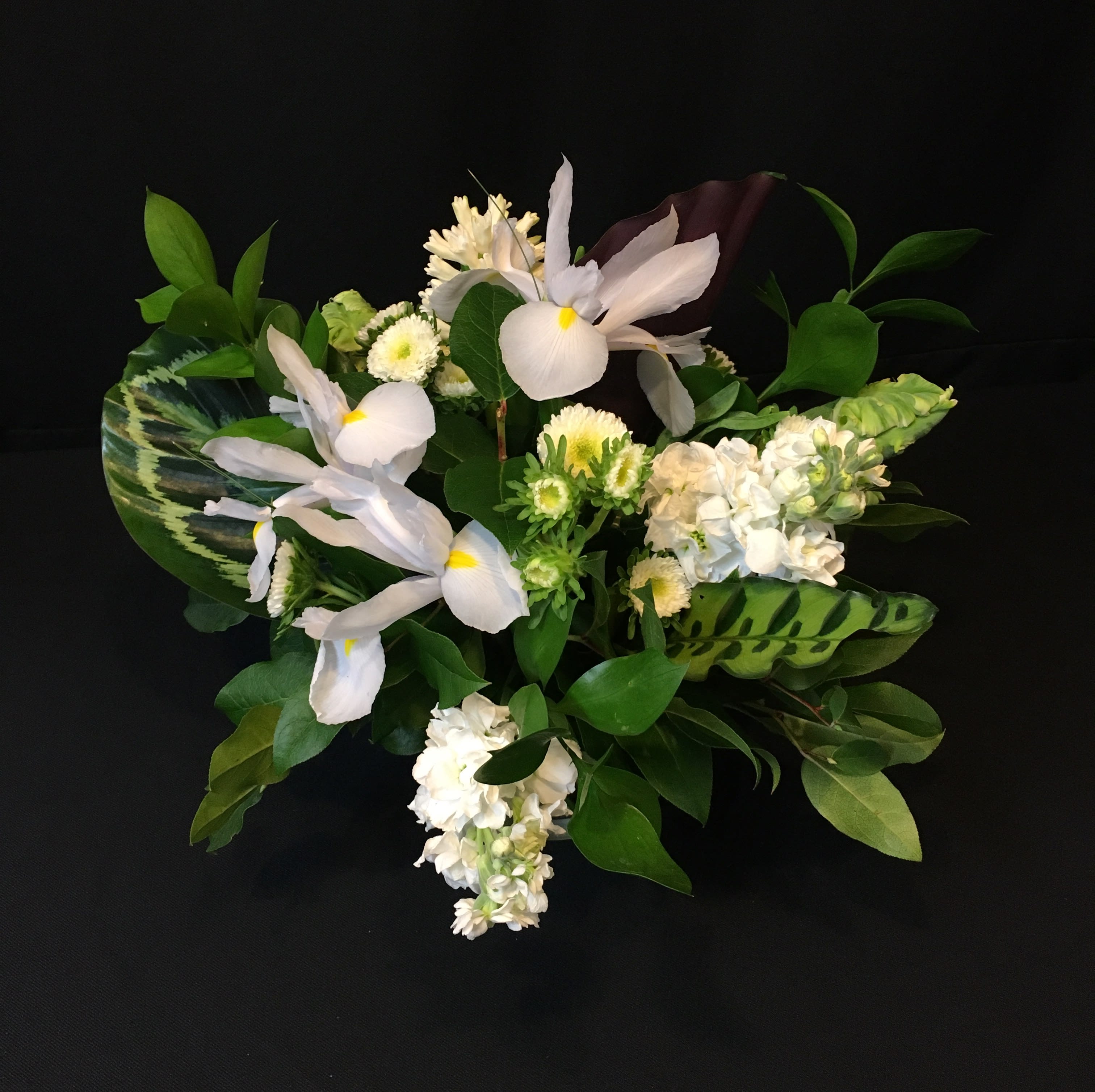 Lush Green Foliage Centerpiece  - Tons of greenery including our most exotic leaves from faraway lands. Bright white pristine flowers of the season will vary. Round centerpiece is beautiful all the way around 360 degrees. Perfect hostess gift, anniversary worthy too. 