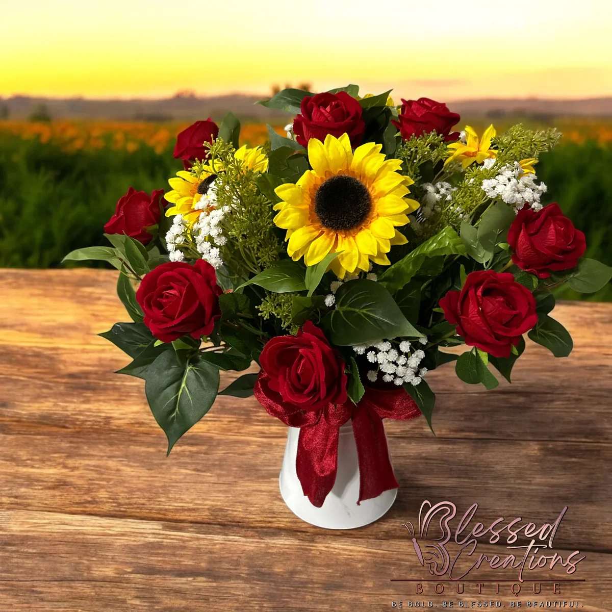 Sunflower and rose floral arrangement - This beautiful floral arrangement features a stunning combination of sunflowers and roses, accented by delicate baby's breath and foliage. Perfect for any occasion, it comes in a white vase with a vibrant red bow to add a touch of elegance. Bring the beauty of the outdoors indoors with this expertly crafted arrangement.