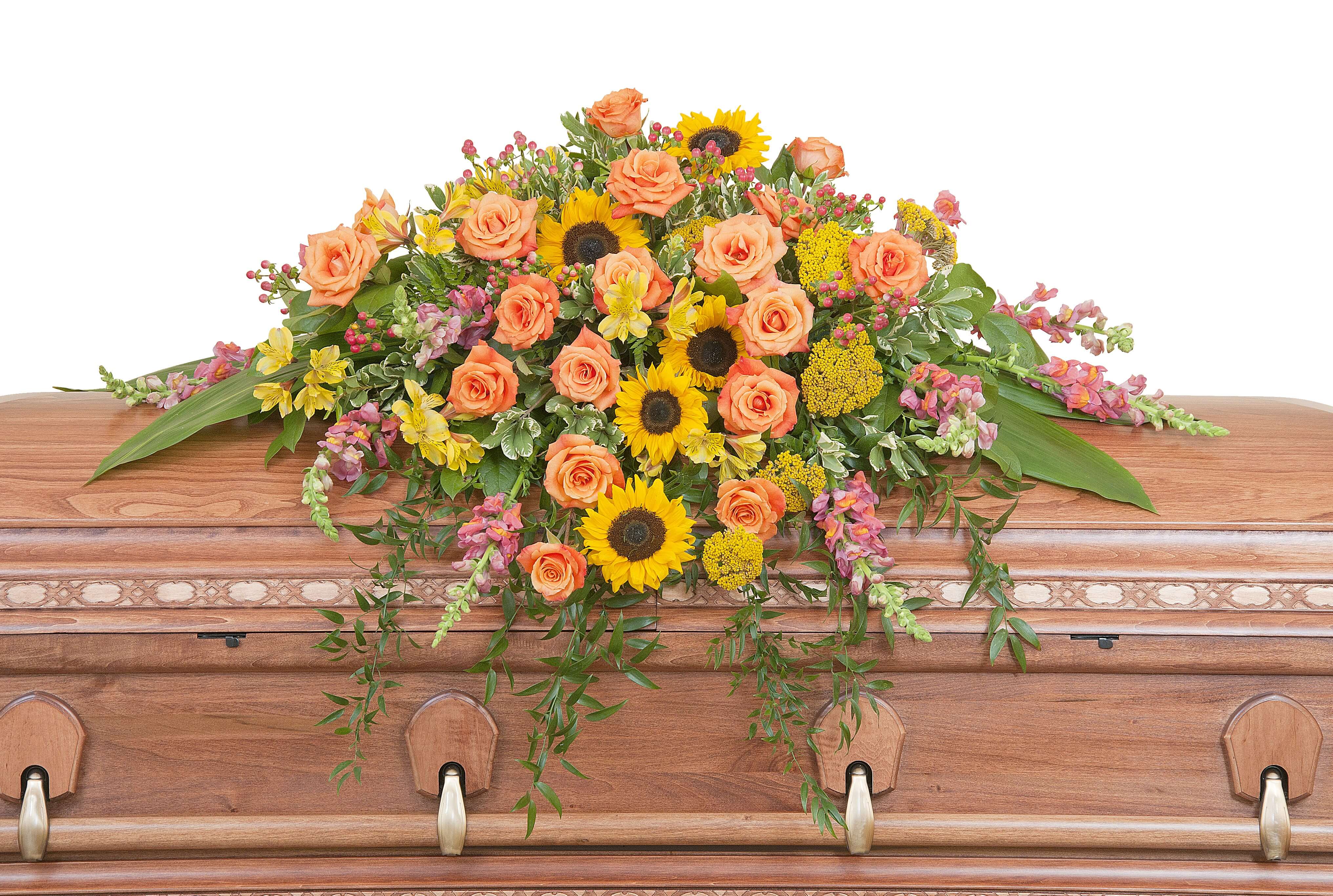 Heaven's Sunset Casket Spray Heaven's Sunset Casket Spray - The colors of sunset are evident in this beautiful spray of Sunflowers and Roses with accents of other premium flowers and foliage.