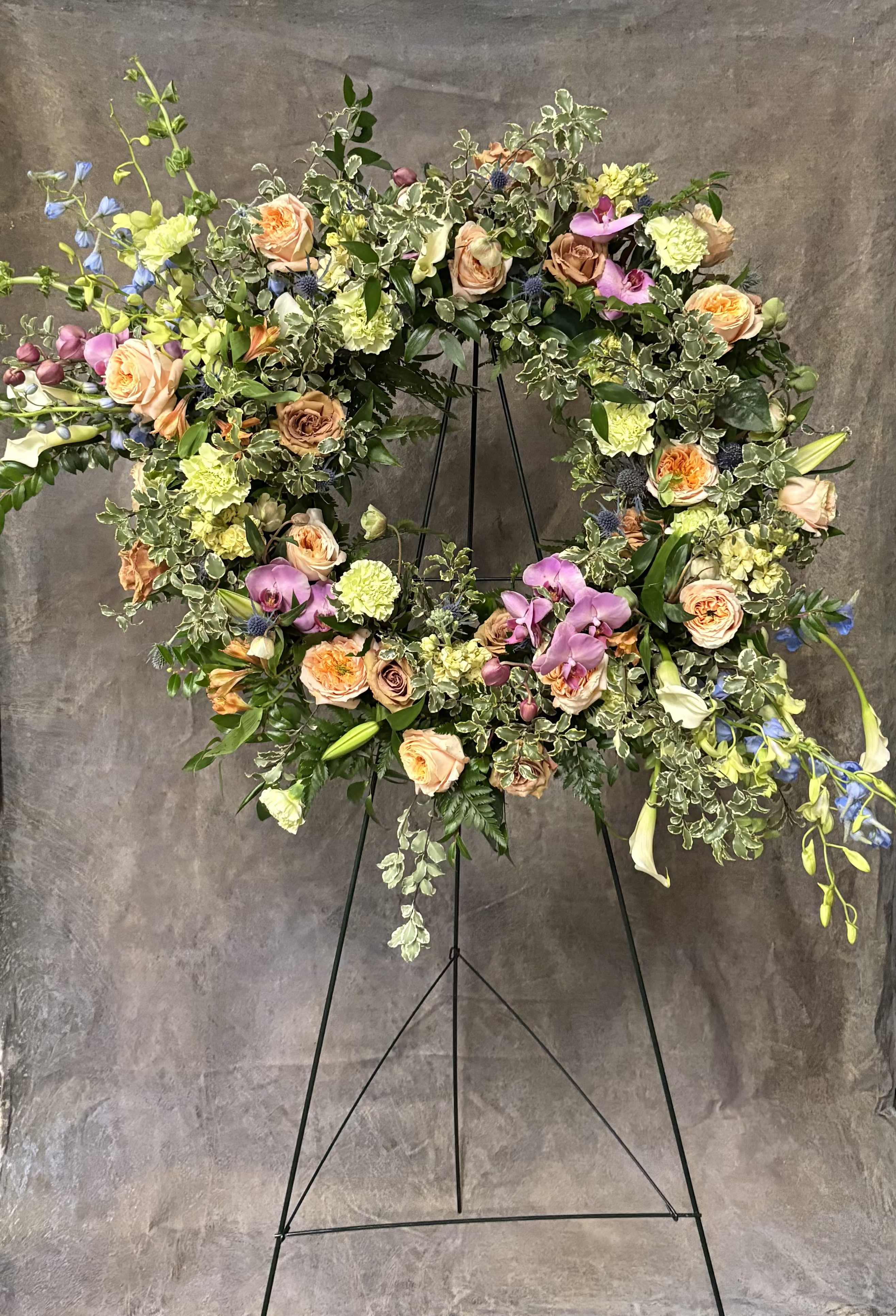 Eternal Horizon Eternal Horizon - "Eternal Horizon" Open Circle Wreath A symbol of unending love and the journey beyond, Eternal Horizon is designed in a graceful open-circle form, allowing light and space to flow through. Lush tropical textures mingle with warm, romantic tones to create a sense of elevation and peace. This wreath speaks to the beauty of a soul set free—bold yet gentle, grounded yet ethereal. A meaningful tribute that whispers of eternity, hope, and the everlasting bond of love.