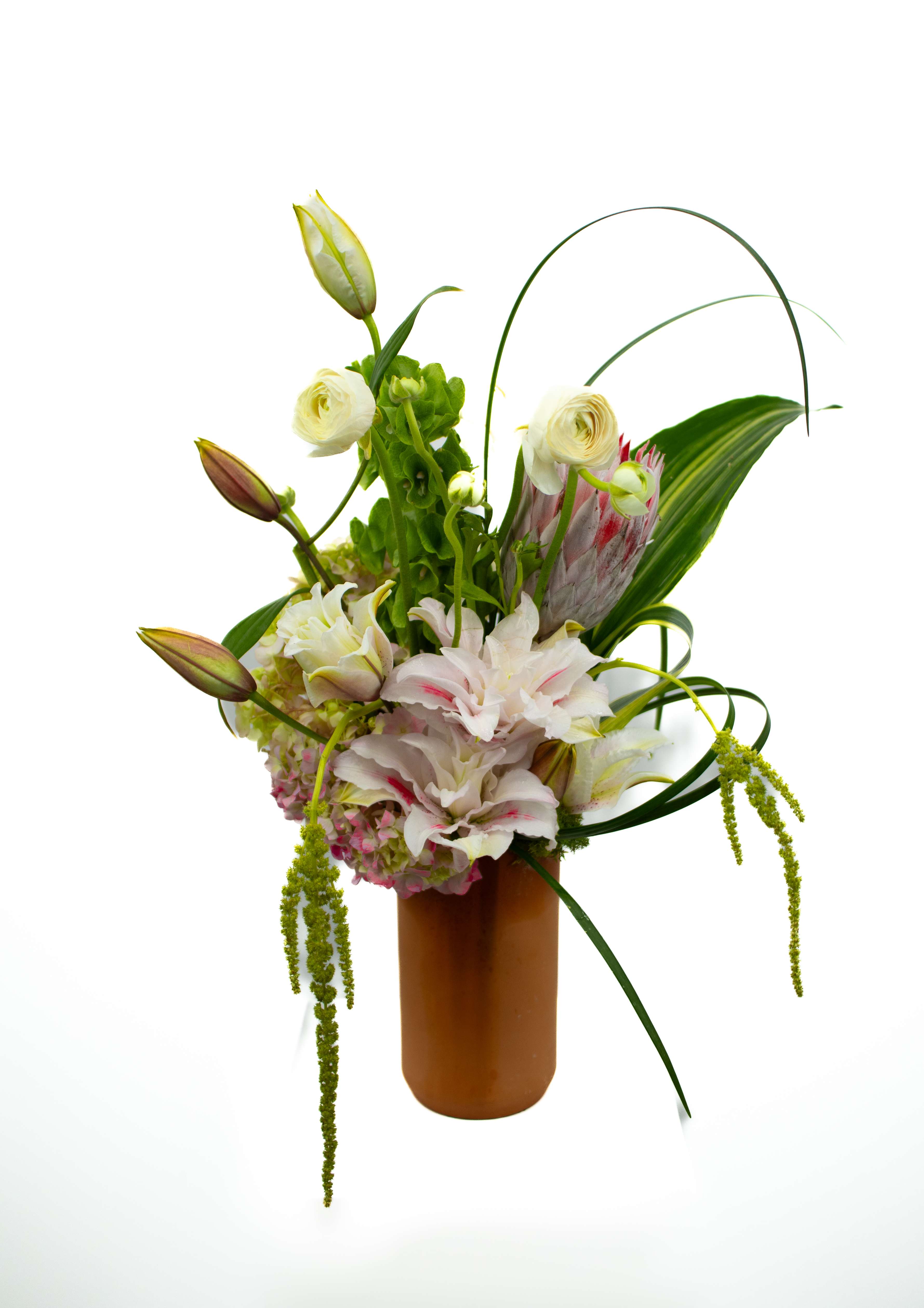 Coby - An arrangement to test design, created with gorgeous Rose Lily's, proteas and other complimentary florals and foliage. All come together to form this amazing and one of kind arrangement.