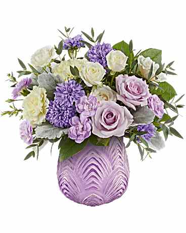 Pastel Glow Bouquet - This breathtaking flower arrangement showcases lavender roses, crème spray roses, light yellow carnations, miniature lavender carnations, and lavender matsumoto asters, beautifully accented with greens. It is delivered in Dreamy Blooms Vase.