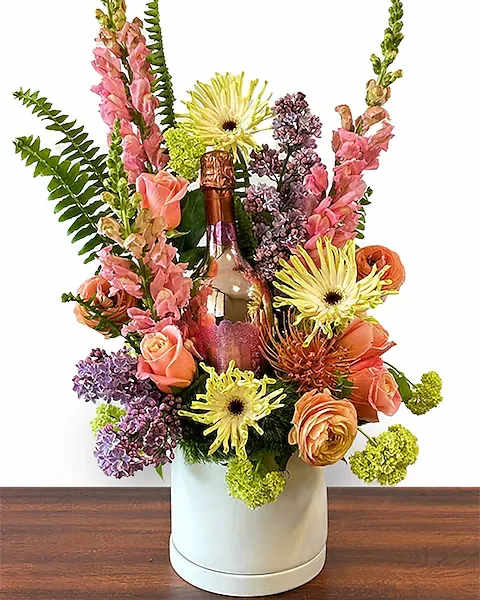 Vibrant Spring - As vibrant and beautiful as a spring morning in Italy. This mix of roses, lilac and other spring seasonals is paired with a bottle of La Ceriola Prosecco. Your choice of Extra Dry or Rose. Either way is Molto Bene! NOTE; MUST BE 21+ TO ORDER. SOMEONE 21+ MUST SIGN FOR THE ARRANGEMENT UPON DELIVERY. Lilac may be substituted should the season end early.   All prices in USD ($)  