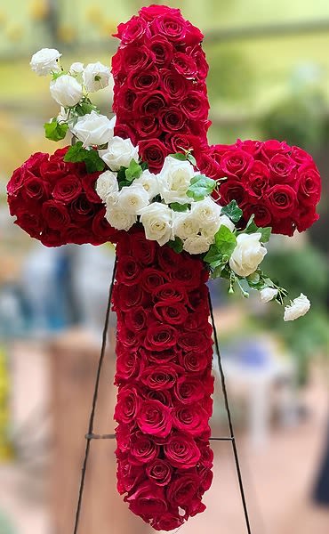 Rose Remembrance Cross - This large dramatic cross is a pave of dozens of roses and accented with a swash of white roses and ivy. Due to the amount of roses and time it takes to create this beautiful remembrance, this cross requires 48 hours notice. On our website you can choose, Red roses with a White rose accent, Pink Roses with a White Rose Accent, or Yellow Roses with a White Rose Accent. If you prefer a different color scheme, call the store directly at 858-454-0146 to discuss availability of product. Approximate Size of DELUXE Cross: 48&quot; Tall x 42&quot; Wide. When mounted on a stand the display stands approximately 6.5 feet tall. Starndard Size is appoximately 24&quot; Tall x 20&quot; Wide  All prices in USD ($)