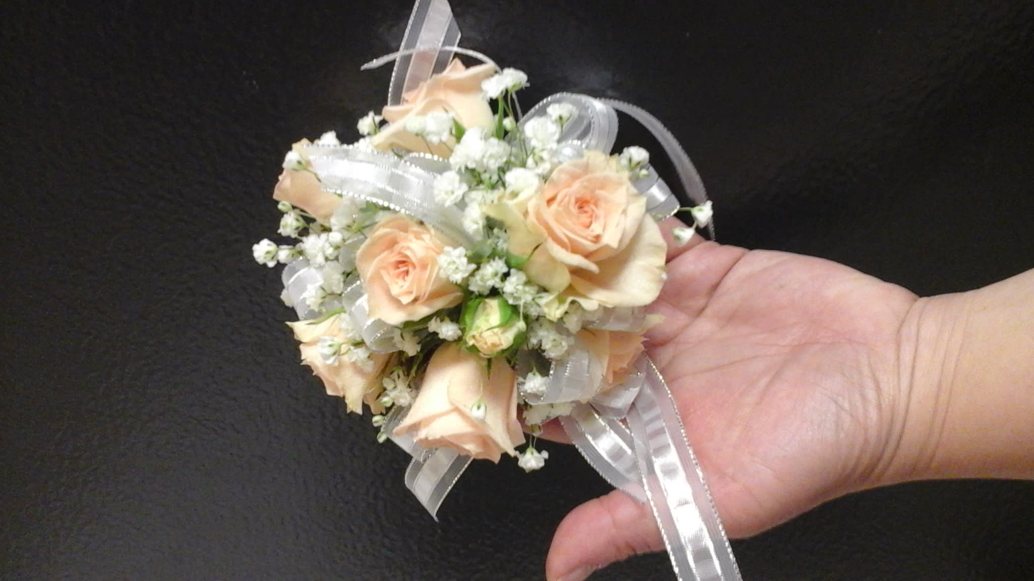 Peach roses corsage Peach roses corsage - This corsage is made with peach spray roses and baby's breath