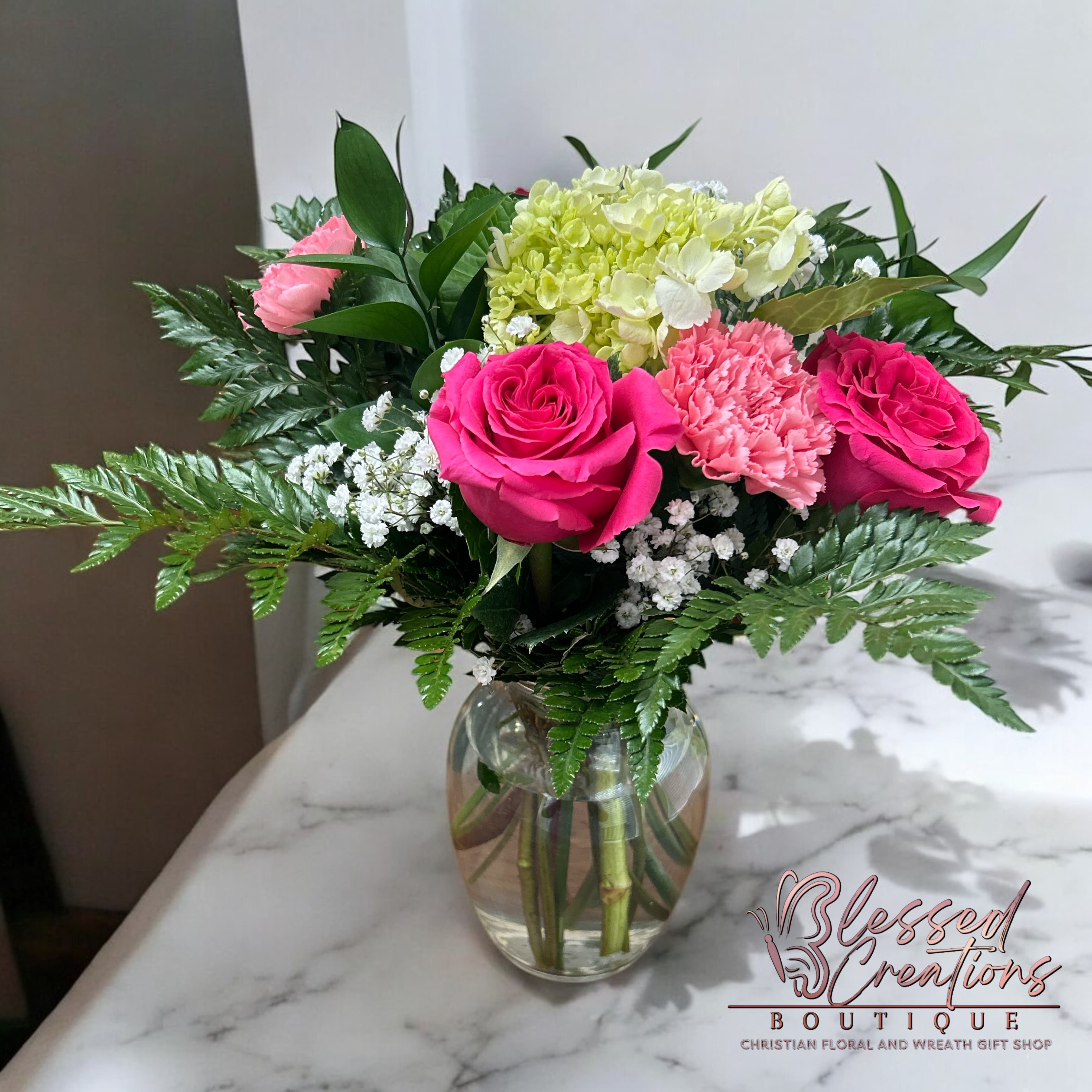 Graceful Blooms - Graceful blooms is a stunning blend of soft elegance and timeless charm. Featuring lush pink roses, vibrant carnations,and mini green hydrangea. Perfect for any occasion. 