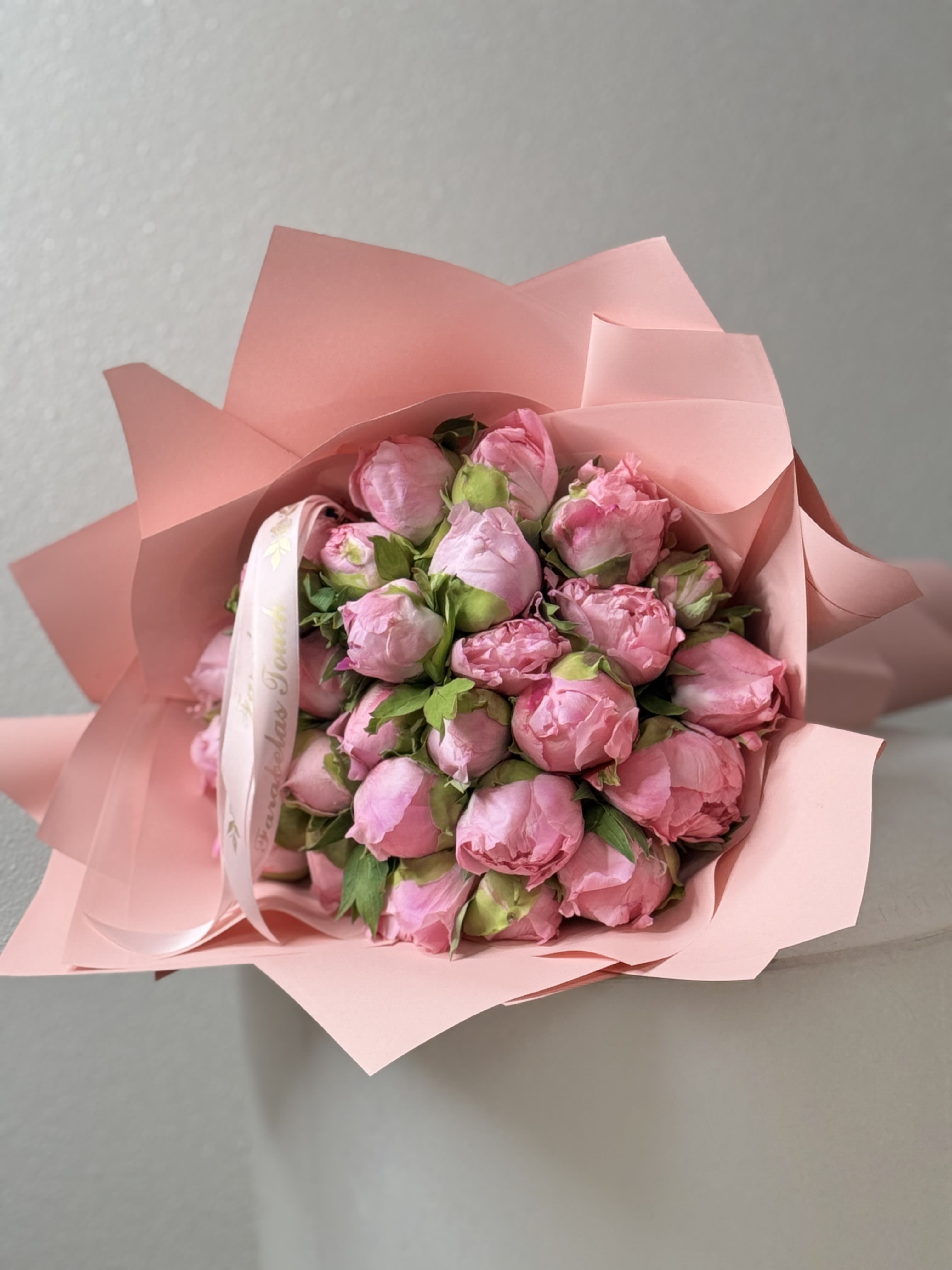 The French Peonies Bouquet -  Indulge in the timeless beauty of our &quot;Eternal Elegance&quot; bouquet, where the soft, romantic allure of peonies meets the classic charm of French floral design. This exquisite arrangement showcases lush, fully bloomed peonies in shades of blush, cream, and soft coral, each petal whispering secrets of grace and femininity.  Wrapped in delicate, vintage-inspired paper and tied with a rustic twine, this bouquet embodies a sense of effortless sophistication. The gentle fragrance of the peonies fills the air, inviting you to embrace the moment and celebrate life’s special occasions, from weddings to intimate gatherings.  Perfect as a gift or a stunning centerpiece for your home, the &quot;Eternal Elegance&quot; bouquet captures the essence of springtime romance. Let its enchanting presence brighten your space and delight your senses, making every day feel like a special event. Experience the artistry of French floral arrangements with this breathtaking bouquet, and let the beauty of peonies speak for themselves.