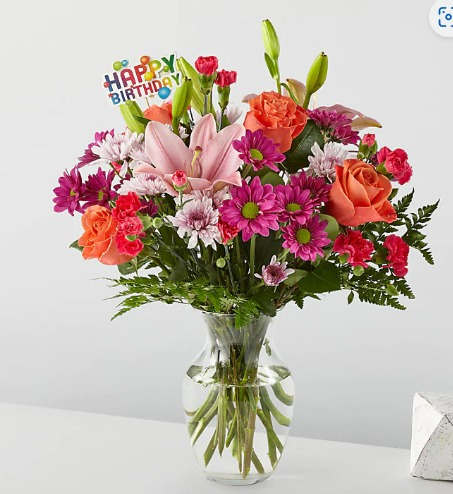 Happy birthday - This floral arrangement has a little of everything Daisies, lilies, roses.