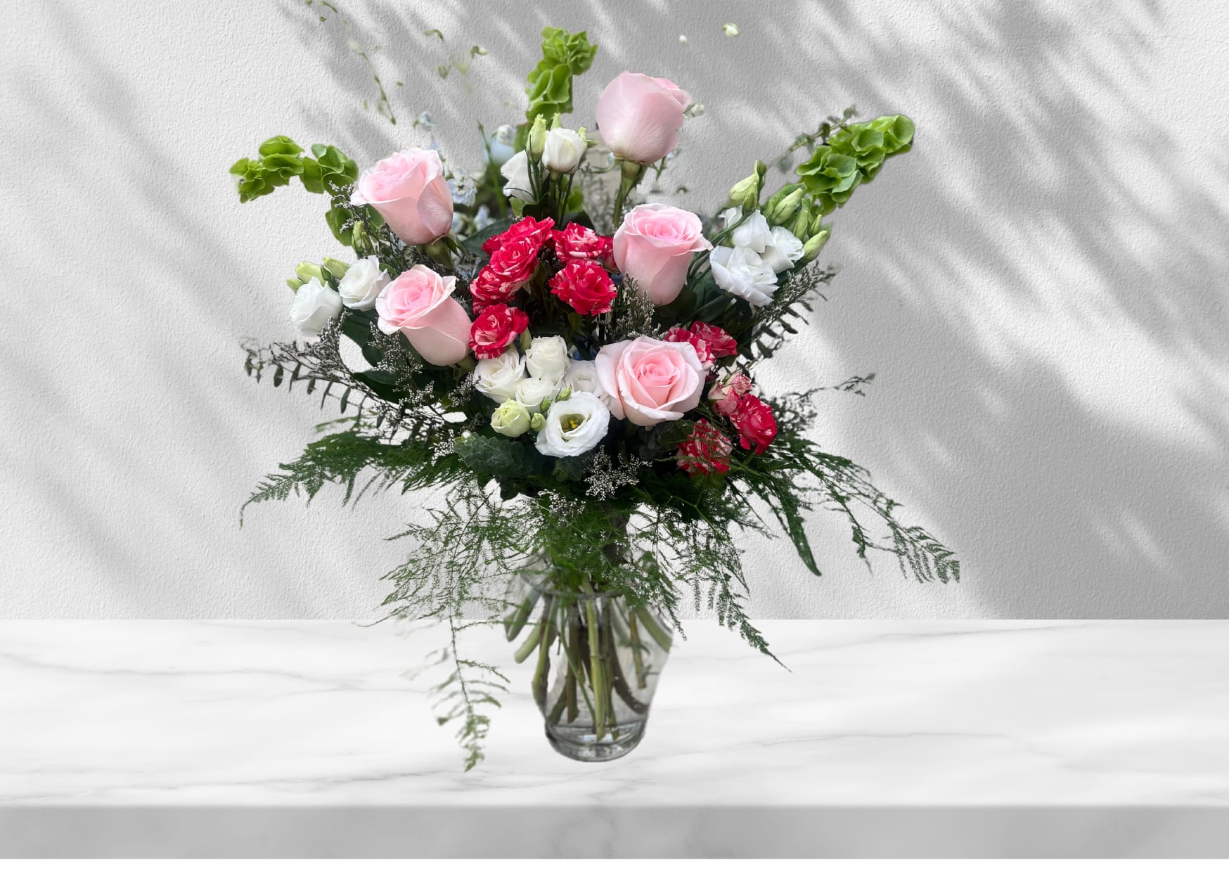 Joyful Blooms - A soft and sweet arrangement filled with Bells of Ireland, Roses, Lisianthus, and more!