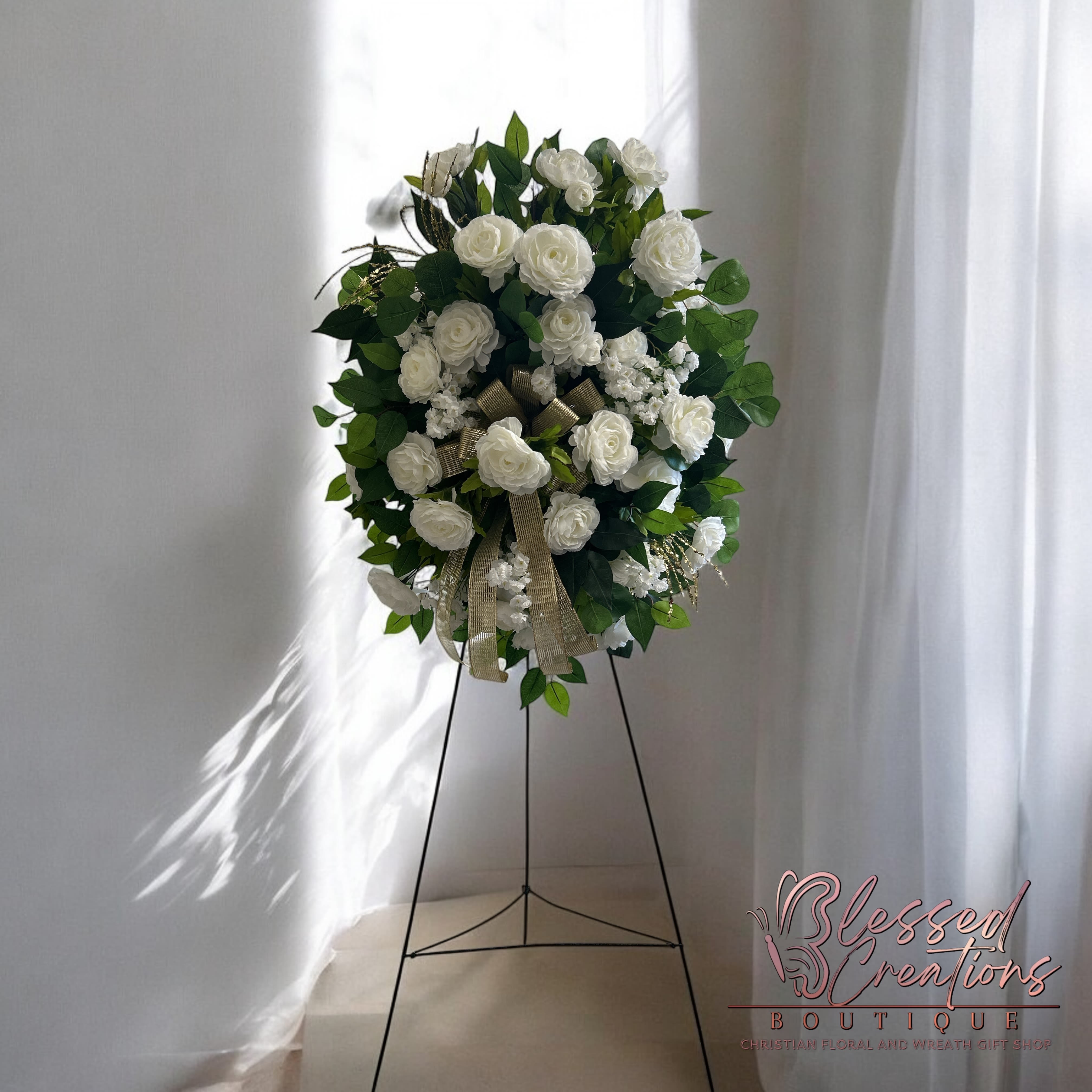 Gold and white silk standing spray  - A beautiful tribute, this sympathy silk standing spray features classic white flowers with soft white accents, highlighted by elegant gold touches and a satin gold bow. A serene and graceful way to express your condolences.