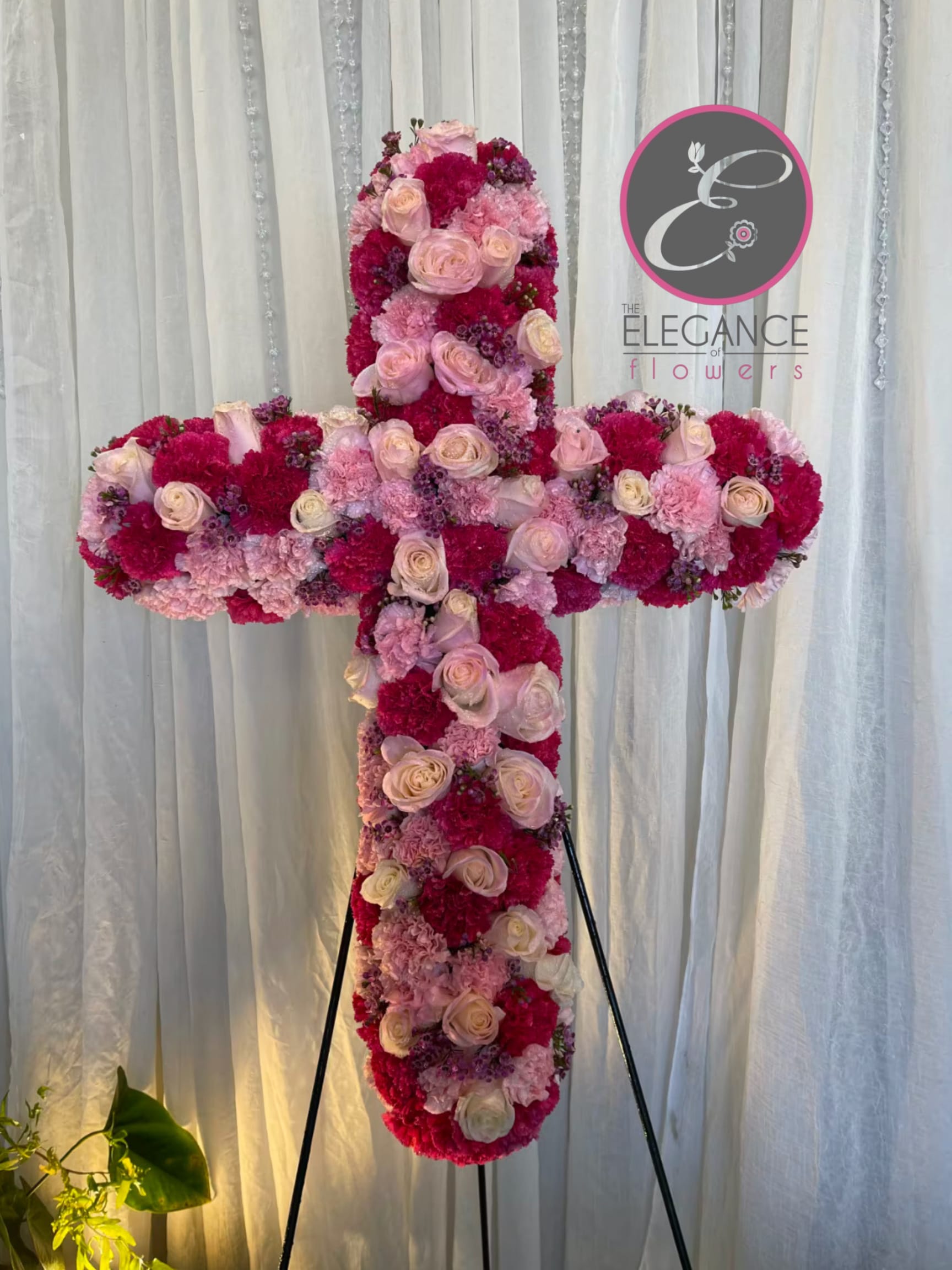Cross Stand #14 Cross Stand #14 - A cross stand for a funeral is a graceful tribute, symbolizing faith and remembrance. Adorned with fresh flowers, it stands as a comforting centerpiece during memorial services.
