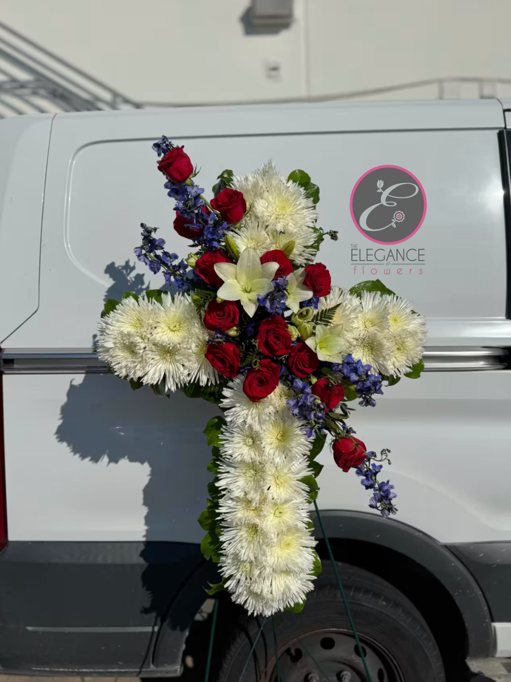 Cross Stand #7 Cross Stand #7 - A cross stand for a funeral is a graceful tribute, symbolizing faith and remembrance. Adorned with fresh flowers, it stands as a comforting centerpiece during memorial services.