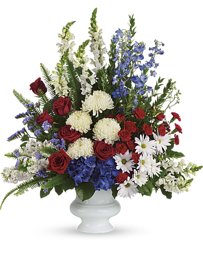 With Distinction - A dazzling display of patriotic red, white and blue flowers sends a silent yet poignant statement about hope, freedom and the strength to endure. This proud bouquet is a testament to life that is sure to be appreciated. A beautiful mix of all-American red, white and blue flowers such as hydrangea, roses, miniature carnations, snapdragons, chrysanthemums and more are perfectly arranged in a white urn.