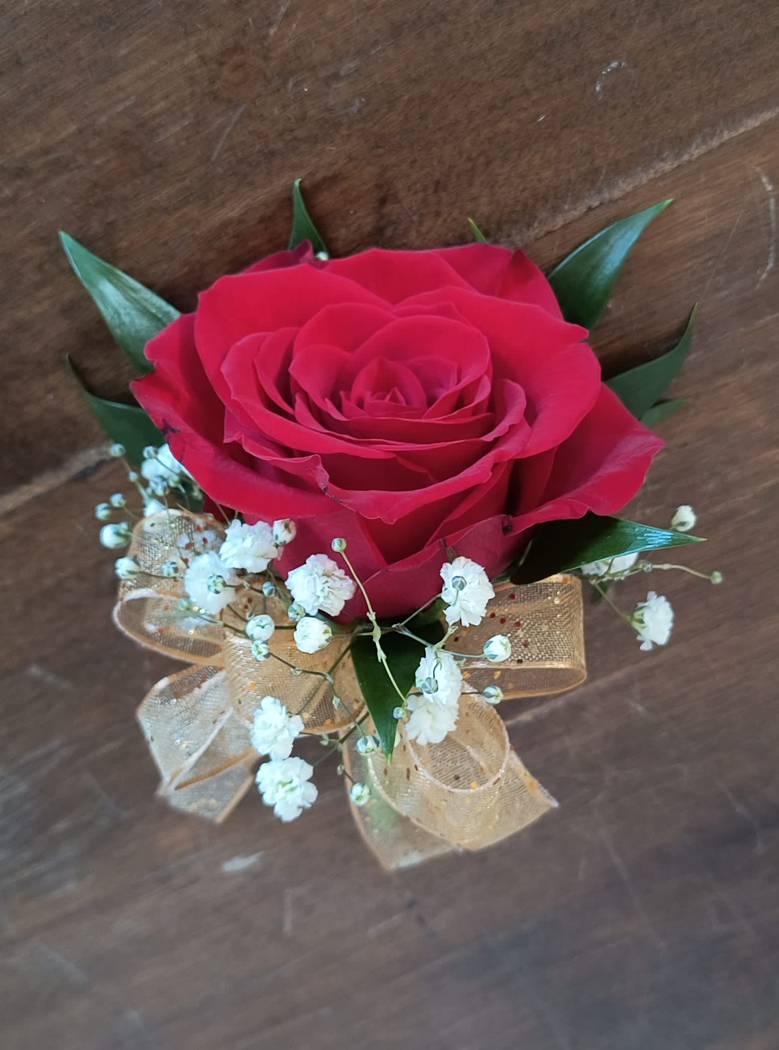 Classic Red Rose Corsage - Classic and timeless, the red rose. Red rose, baby's breath, greens and a gold ribbon. This corsage is pin on style.