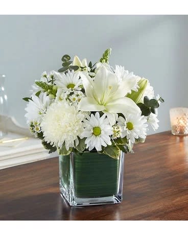 Healing Tears All White - There is an innocence to all souls that is evoked in an expression of pure white. Our sympathy arrangement of angelic white roses, lilies, mums, daisy poms and more, expertly arranged in a clear glass cube lined with a Ti leaf ribbon, makes for an exquisite gesture of comfort and healing. Arrangement of white roses, Asiatic lilies, football mums, snapdragon, daisy poms and monte casino; accented with fresh greenery Artistically designed by our florists in a classic clear glass cube lined with a Ti leaf ribbon; vase measures 5&quot;H x 5&quot;D Premium arrangement measures approximately 11&quot;H x 11&quot;L Deluxe arrangement measures approximately 10&quot;H x 10&quot;L Standard arrangement does not include roses and measures approximately 9&quot;H x 9&quot;L Perfect gift for delivery to the homes of family members or friends Our florists hand-design each arrangement, so colors, varieties, and container may vary due to local availability Lilies may arrive in bud form and will open to full beauty over the next 2-3 days Delivery/Substitution Policy  