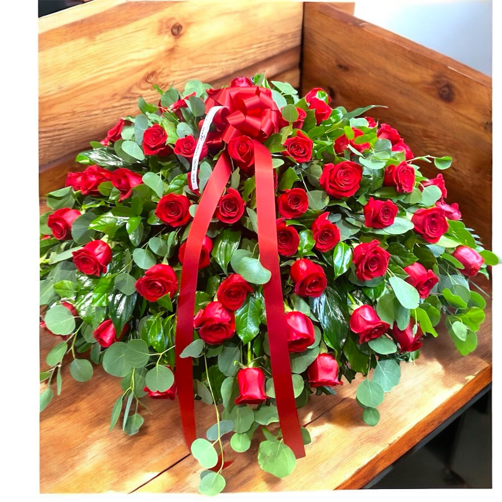 Red roses Casket Spray - With dignity and grace, brilliant red roses express the depth of your heartfelt feelings, and the tenderness of your everlasting devotion. 