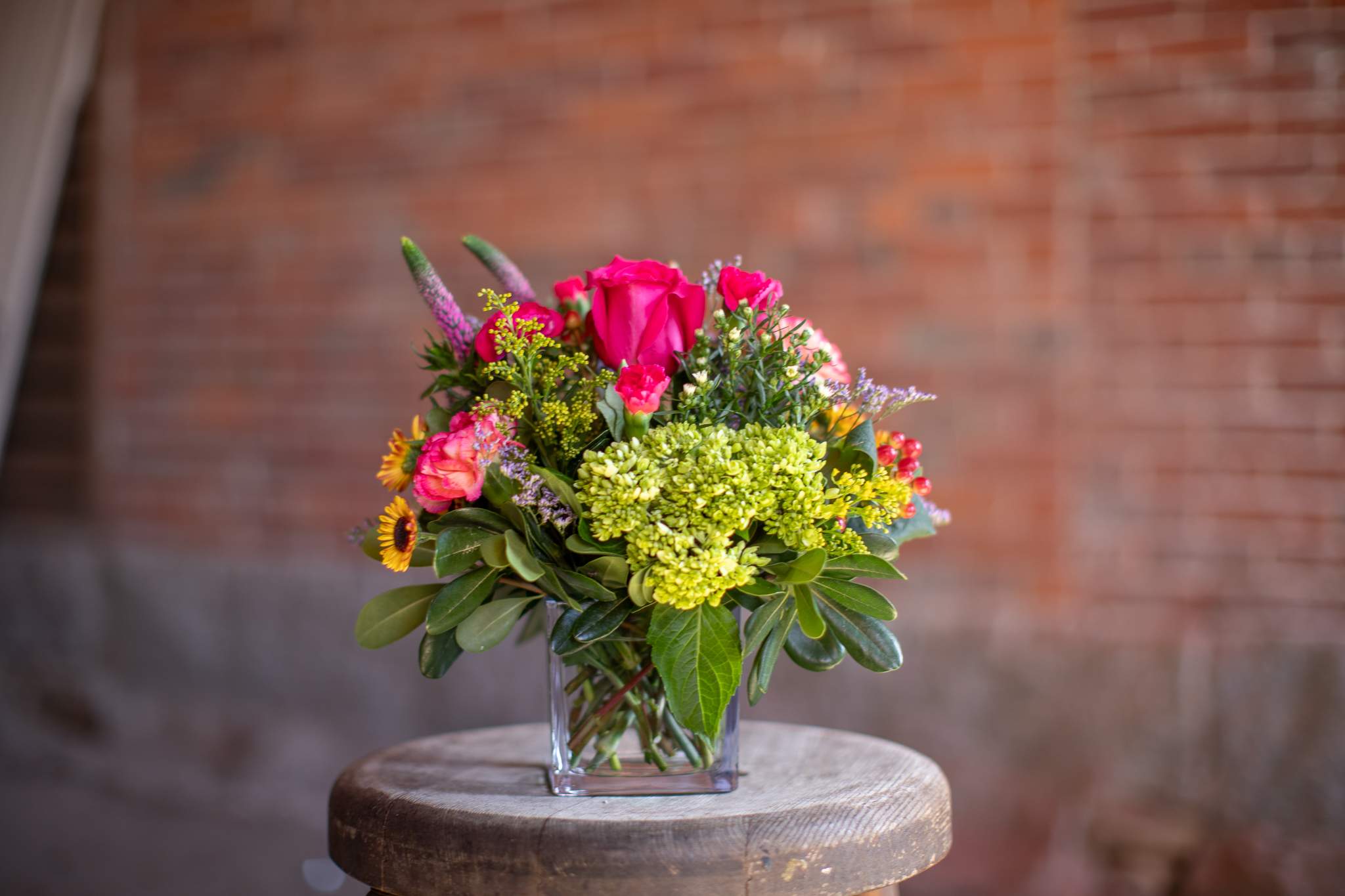 Color Cubed - Bold and bright flowers arranged in an all around fashion in a petite cube shaped vase. Assortment generally include carnations, roses, hydrangea, and or alstroemeria. Complete with accent flowers like solidago, asters, babies breath and/or limonium. These arrangements are a perfect &quot;Pick me up,&quot; for all occasions. 