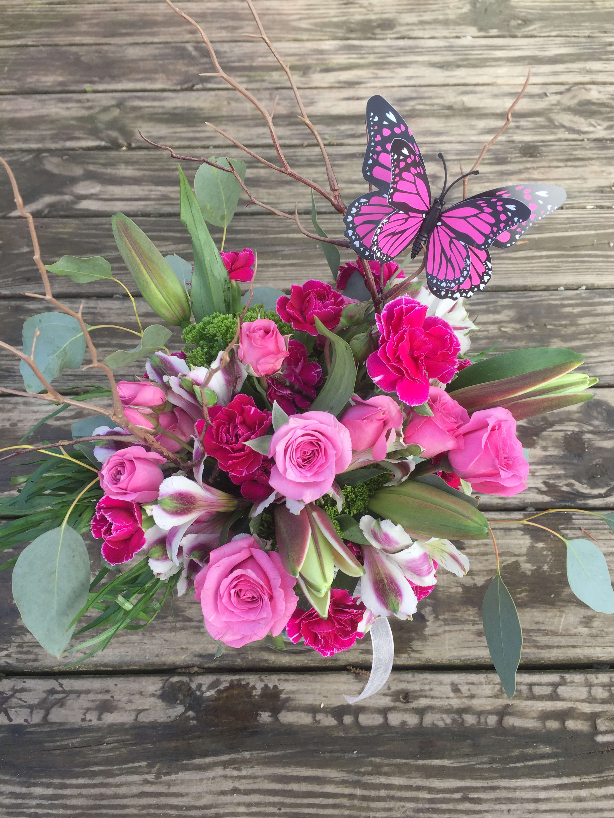 Sweet Success - A colorful pink arrangement with hot pink mini carnations, pink spray roses complete with a butterfly. Great for a birthday, anniversary or just because.
