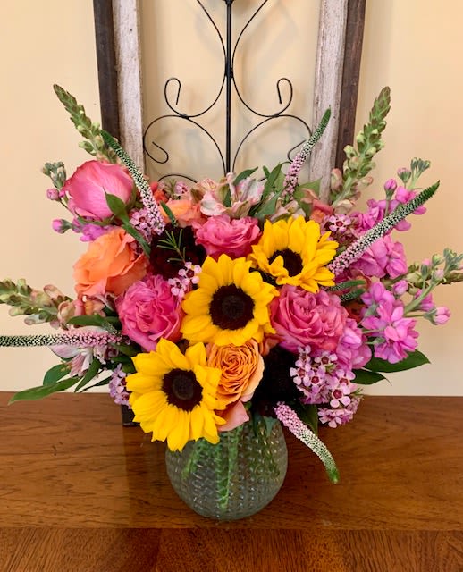 Beauty &amp; Wonder - A mixed fresh cut consisting of Sunflowers, Roses, Snapdragons, Stock, Scabiosa, Alstromeria, Veronica, and Waxflower in shades of Pink, Orange, and Deep Purple.  If you like the look and style of this arrangement but have a smaller budget, head on over to our Designer's Choice Option and choose the budget that suits your needs best.  We will be happy to make a smaller version for you of arrangements that we currently have available in stock.  Let us know which one you are interested in when placing your order.