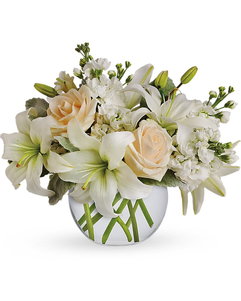 Isle of White - Like a vacation for the senses, this lovely bouquet delivers an oasis of beauty and elegance. Soothing, serene and very special. Crème roses, white asiatic lilies and stock stem are incredibly arranged in a bubble vase. When it comes to bouquets, this is definitely the right way to do white.Approximately 14&quot; W x 11 1/2&quot; H